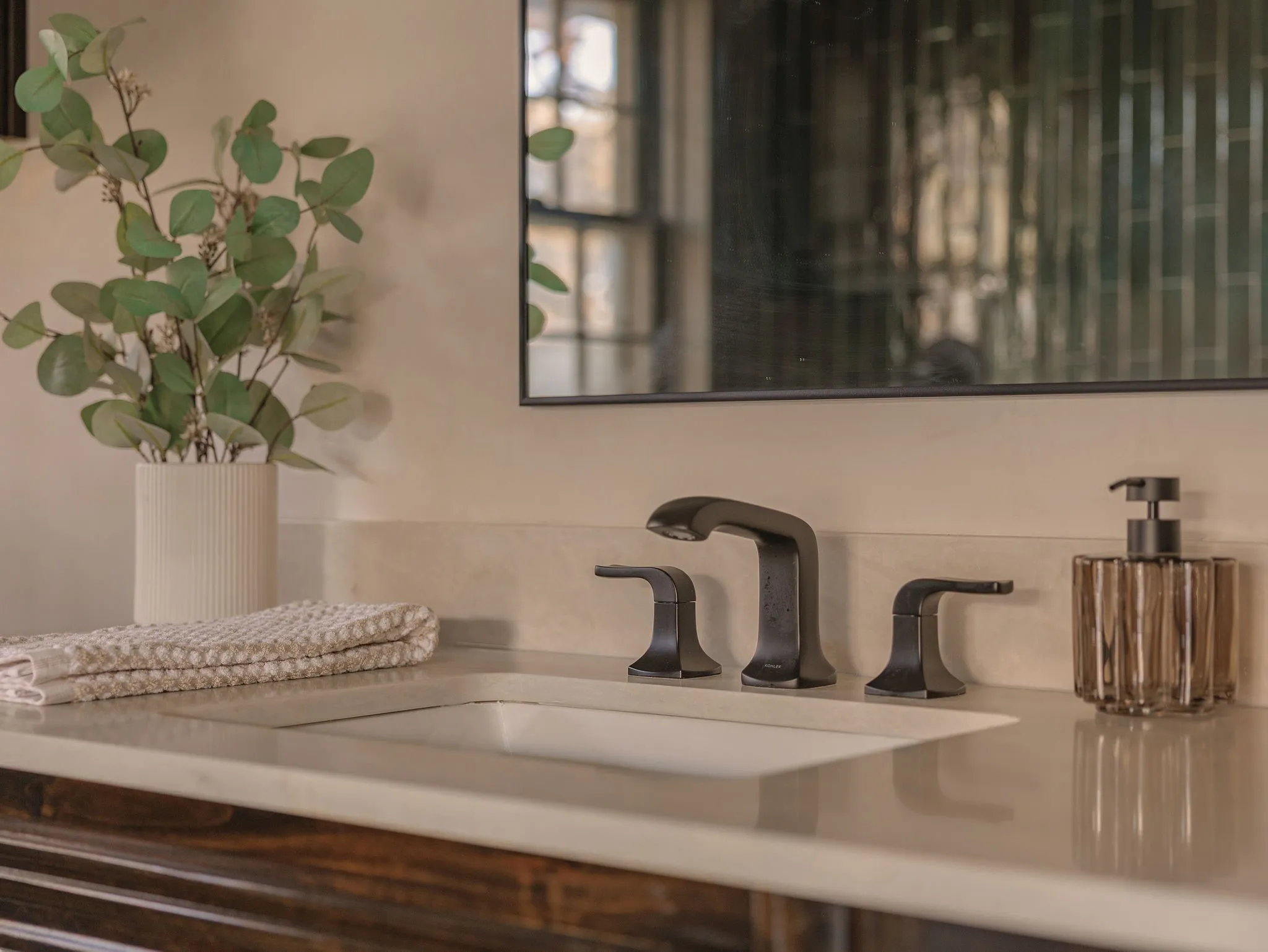 Custom walnut vanities and hand finished Roman clay walls bring warmth and depth to the primary bath.