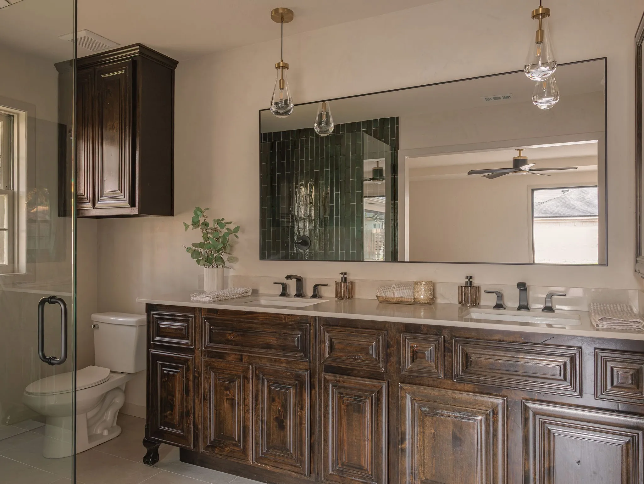 Natural materials, custom walnut vanities and Roman clay walls give the primary bath a collected, understated feel.