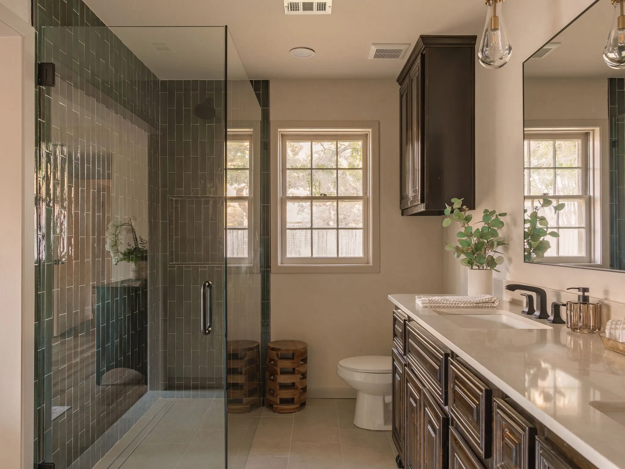 The redesigned primary bath pairs custom walnut vanities with Roman clay walls and rich, textural finishes.