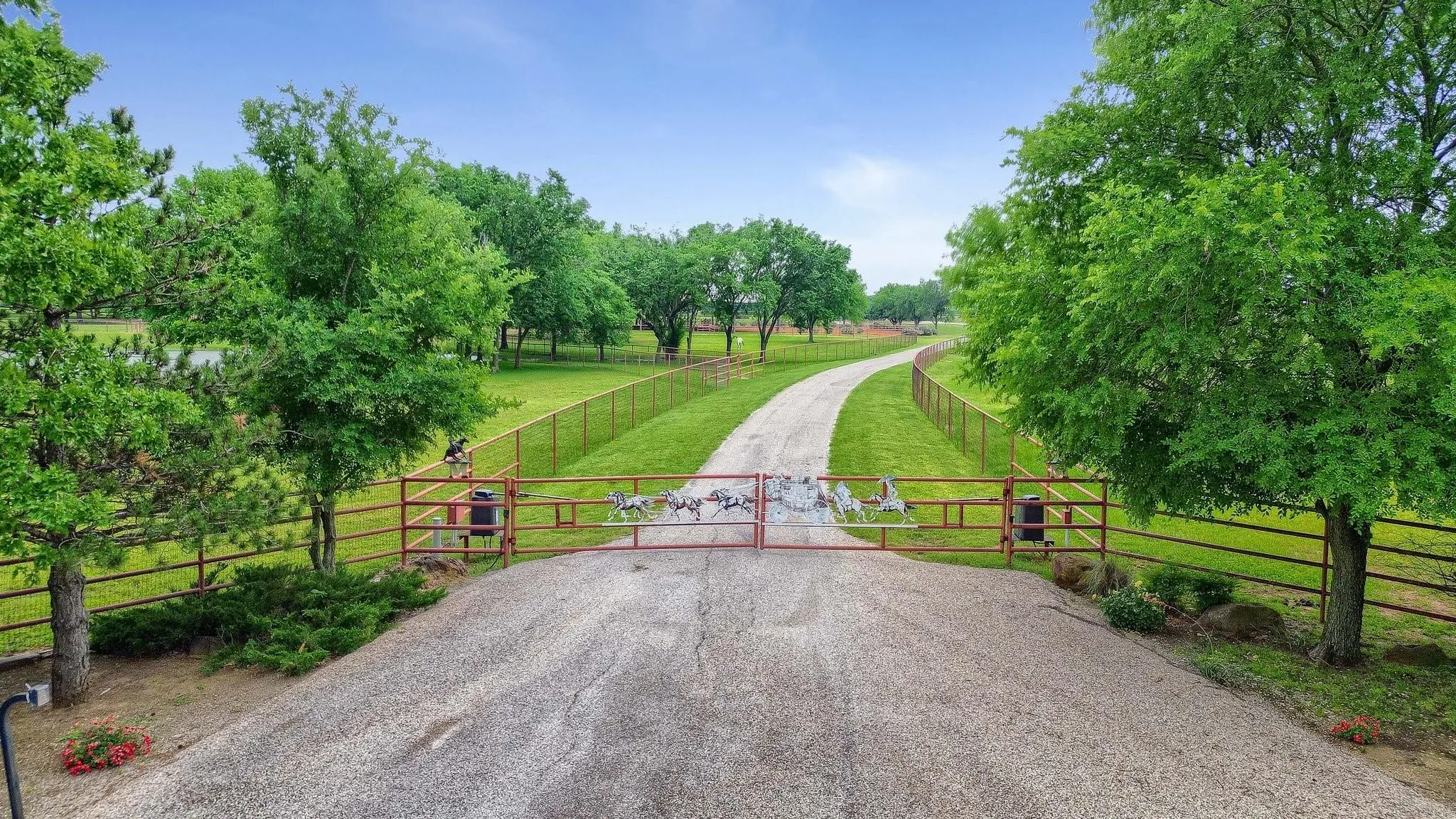 View of asphalt road featuring a gate and a view of rural / pastoral area