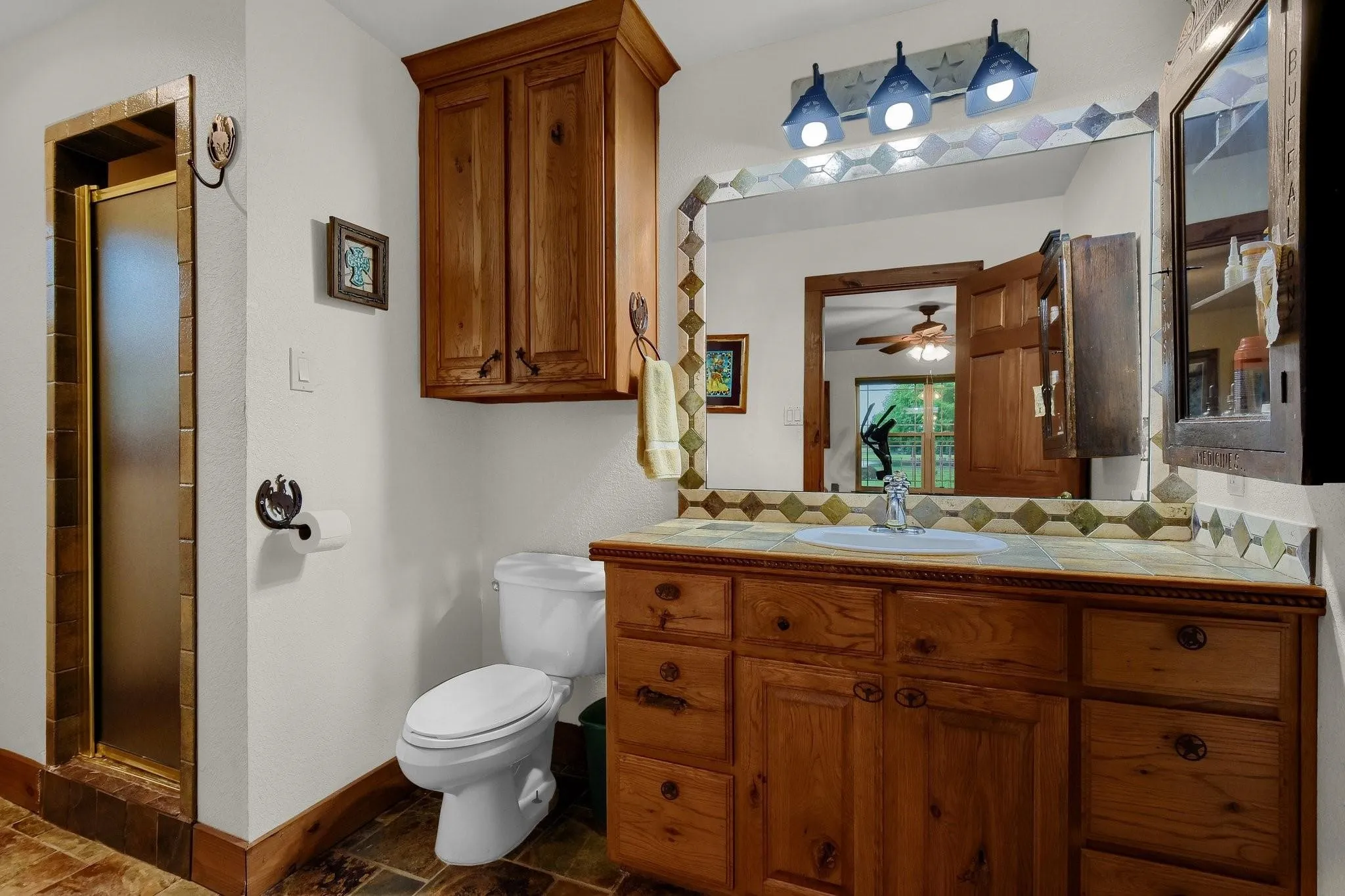 Full bath featuring decorative backsplash, a shower stall, vanity, and ceiling fan