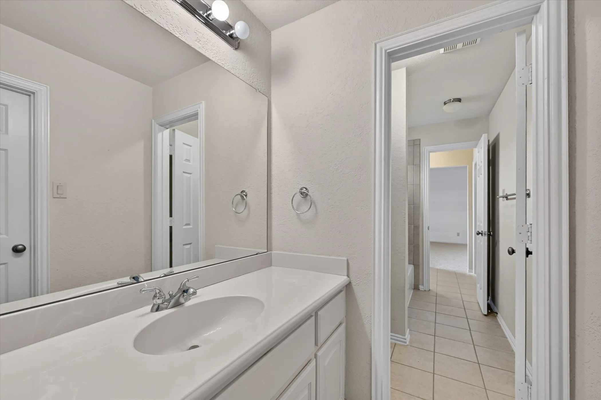 White vanity with an integrated sink and chrome faucet