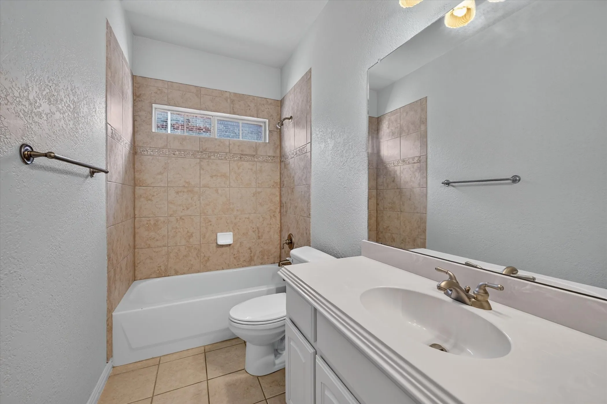 Built-in bathtub with shower, tiled surround, and integrated window