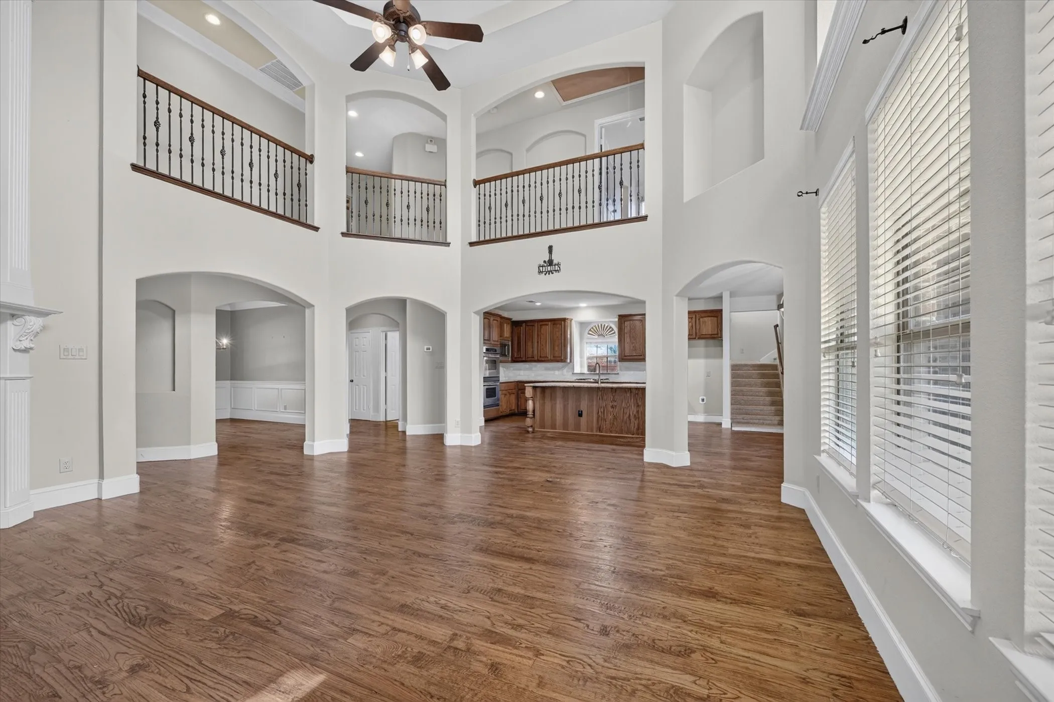 Two-story living area with wood-finish flooring and arched doorways