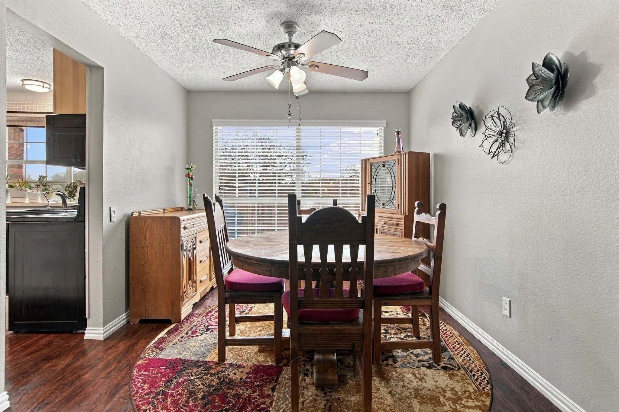 Dedicated dining area ceiling fan with integrated lighting, window with blinds, light-toned walls, white trim