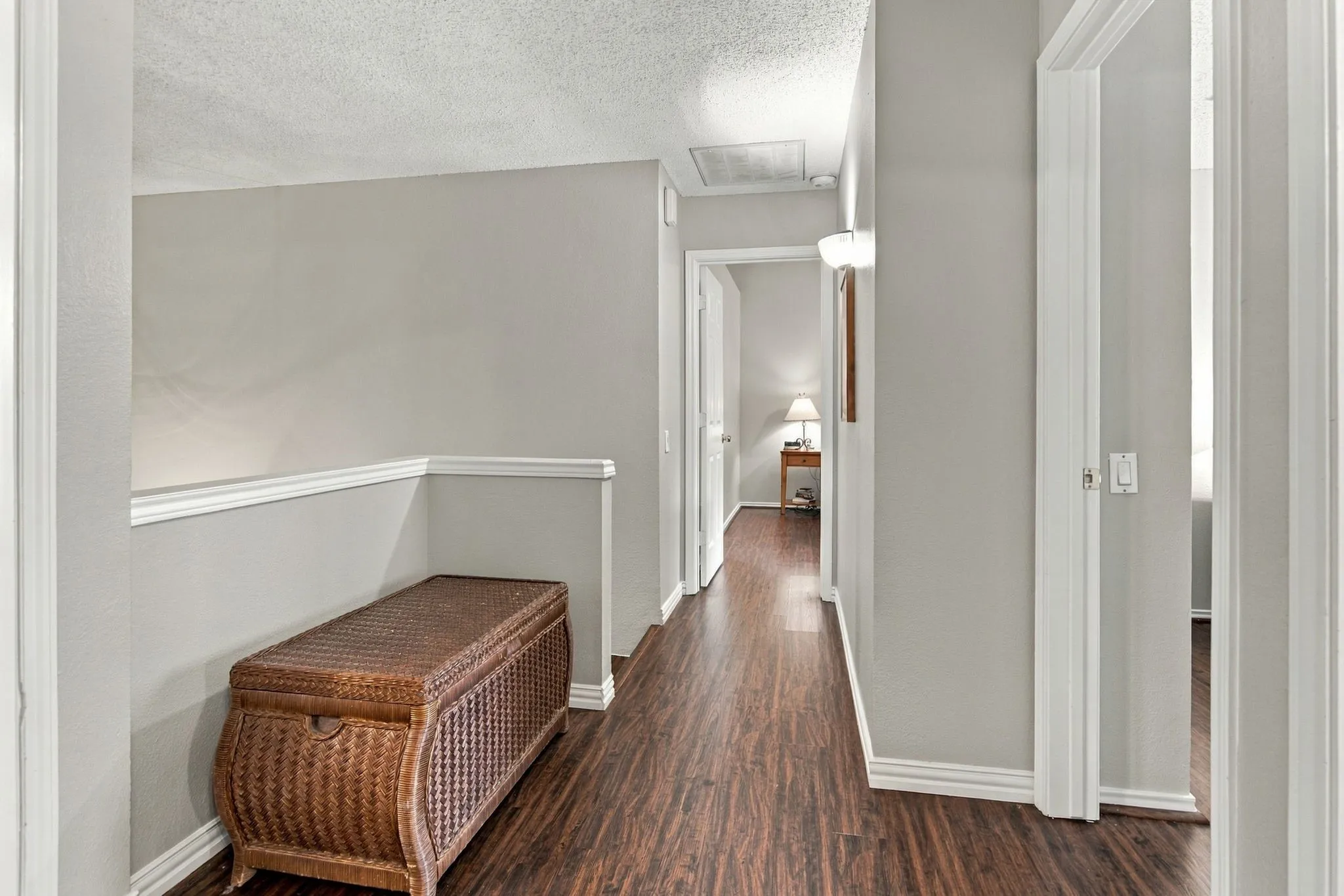 Wood-finish flooring throughout, light gray wall color, white crown molding, and white door frames