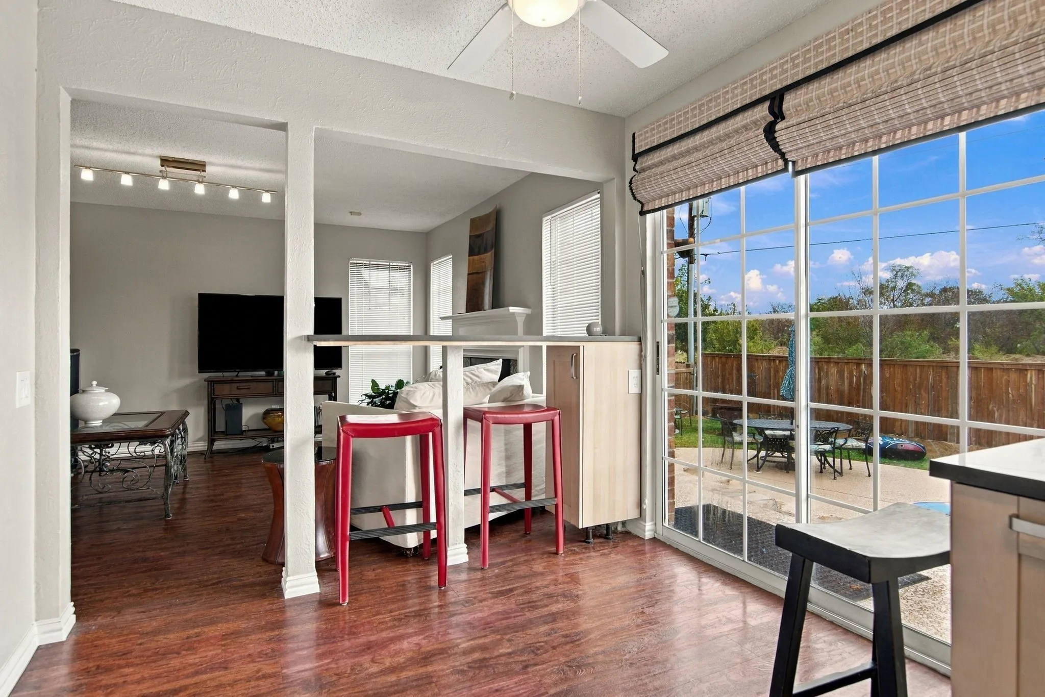 Open concept living space featuring wood-finish flooring, a breakfast bar, and track lighting