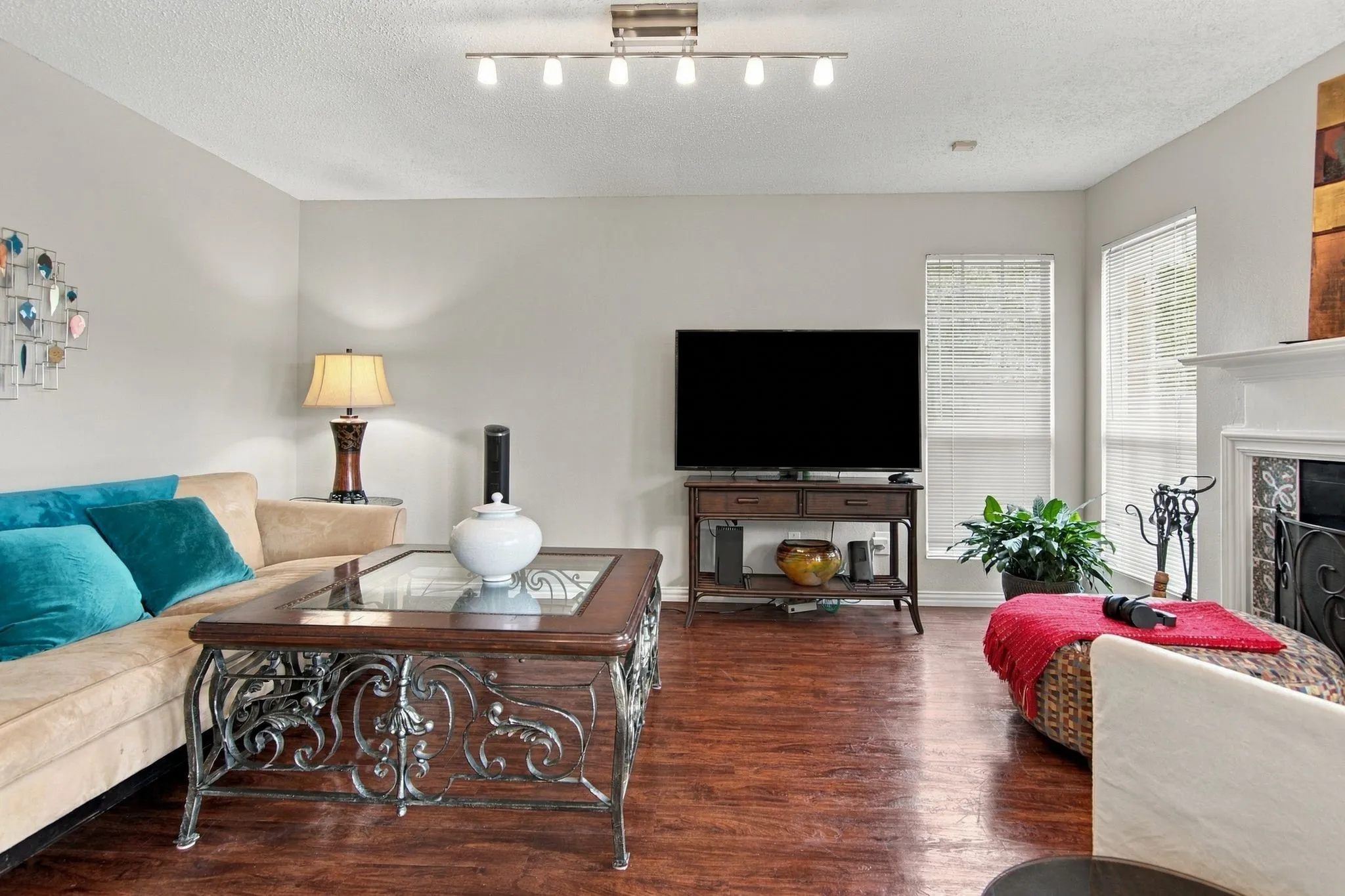 Recessed lighting, wood-finish flooring, white window treatments, and a built-in fireplace