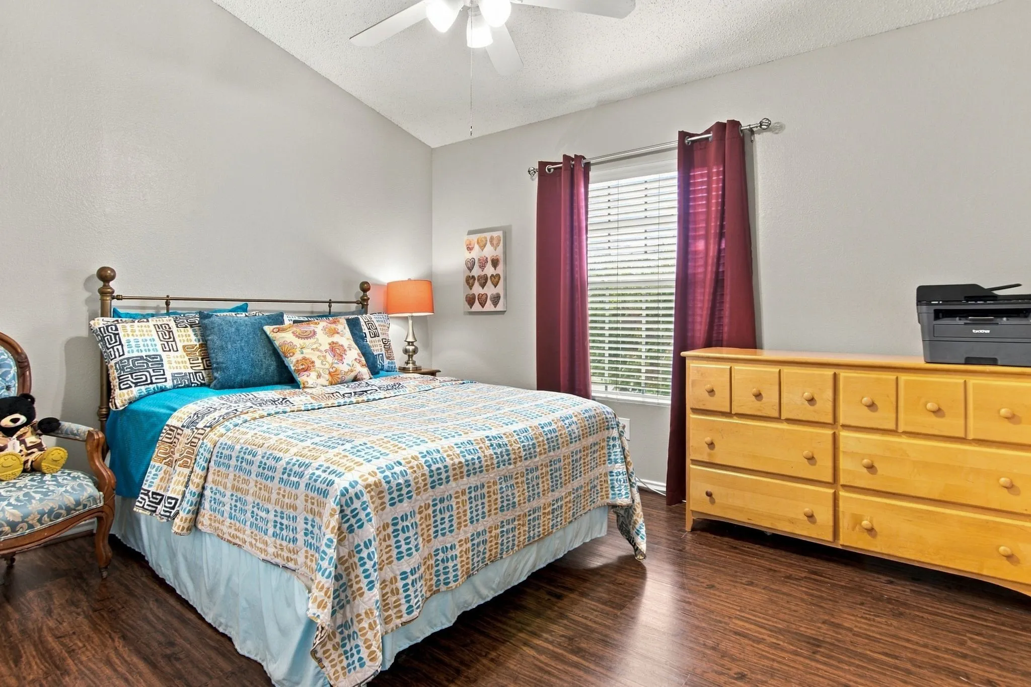 Vaulted ceiling, wood-finish flooring, ceiling fan, and window with blinds