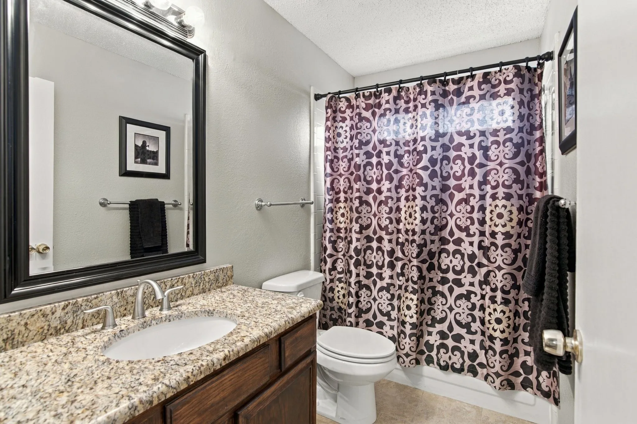 Vanity with granite countertop, undermount sink, and brushed nickel faucet