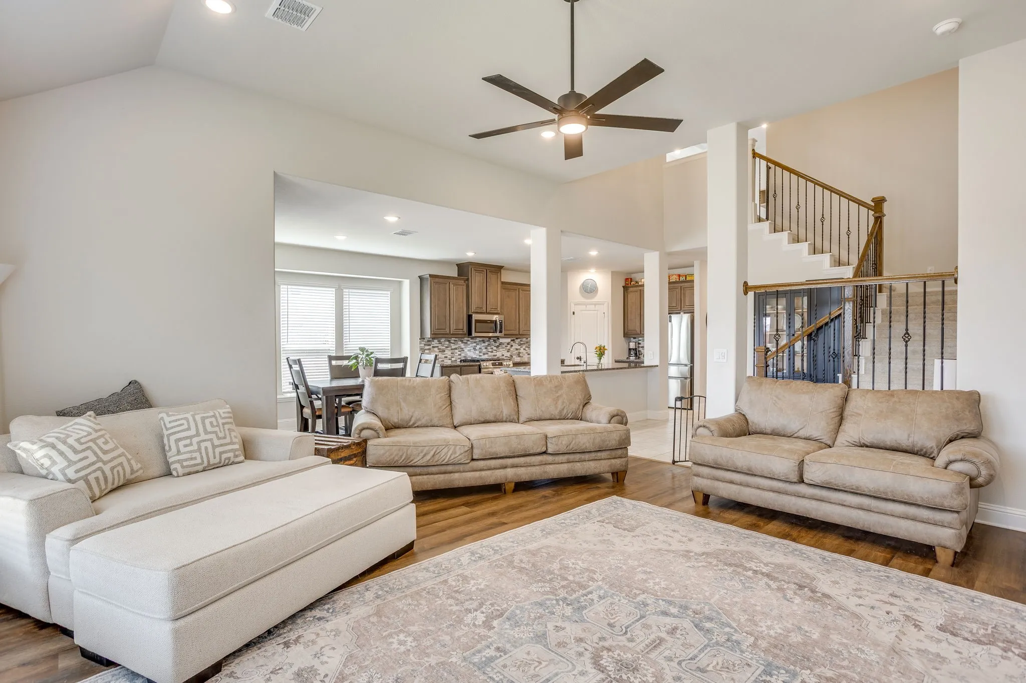 Open-concept living area featuring wood-finish flooring, recessed lighting, and a ceiling fan