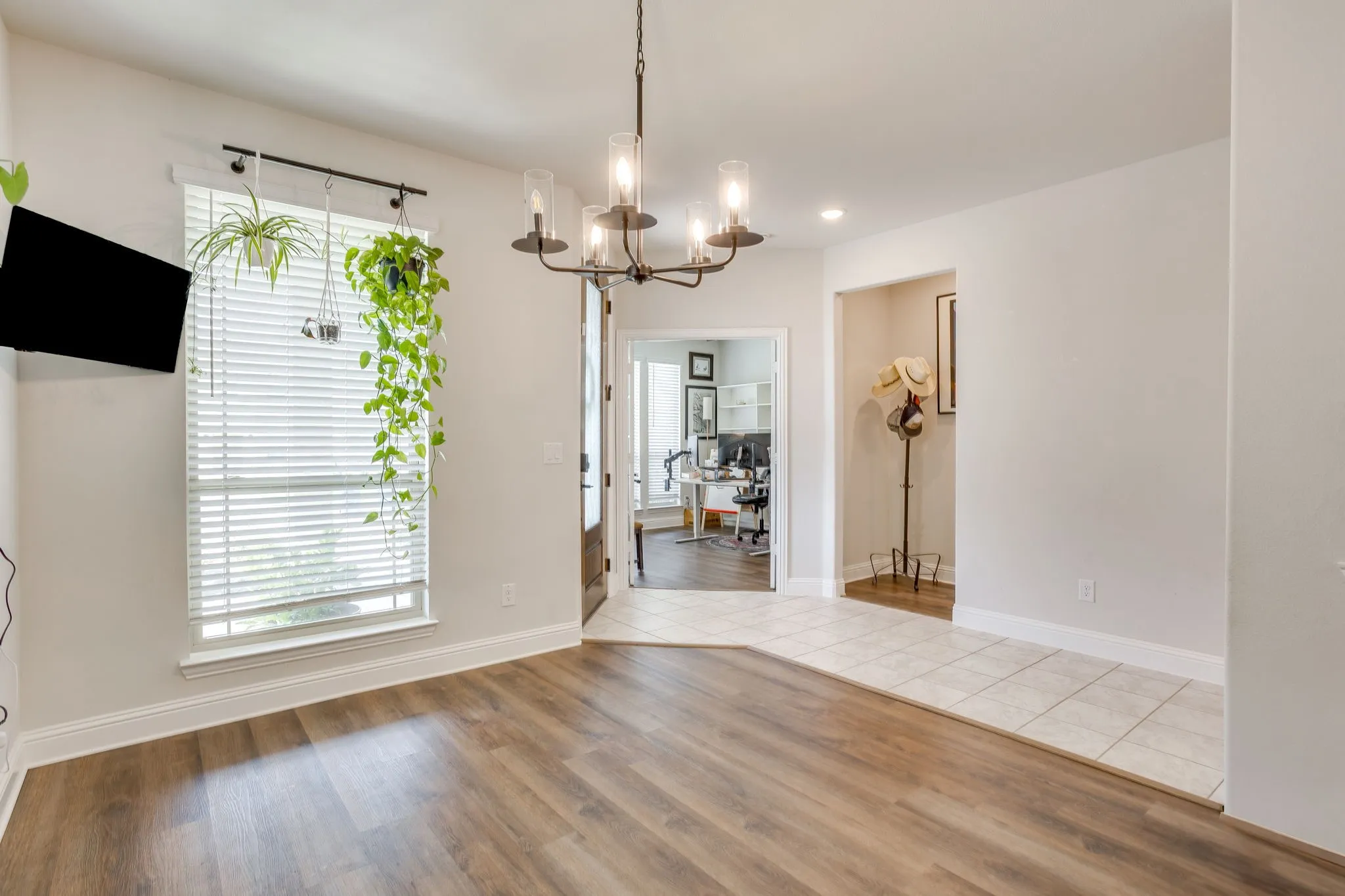 Wood-finish flooring, recessed lighting, and a modern chandelier