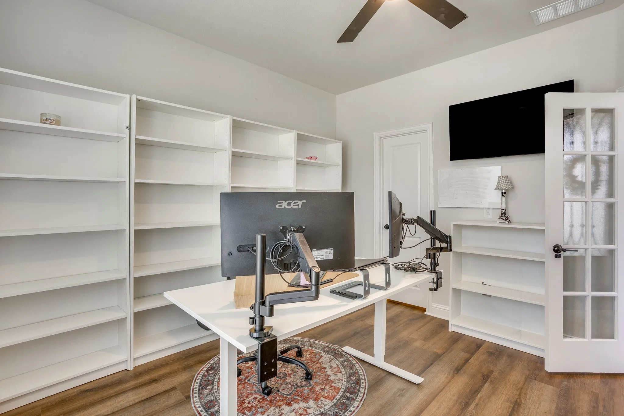 Room featuring extensive built-in shelving, wood-finish flooring, and a ceiling fan