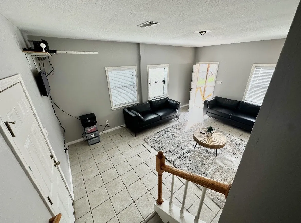 Tiled flooring throughout, multiple windows with blinds, and white trim accents