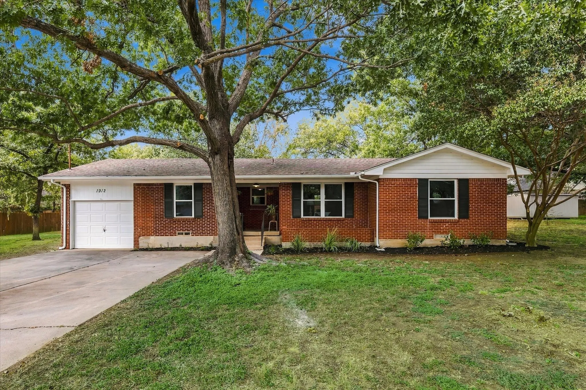 Mature trees surround this all brick home on a large lot