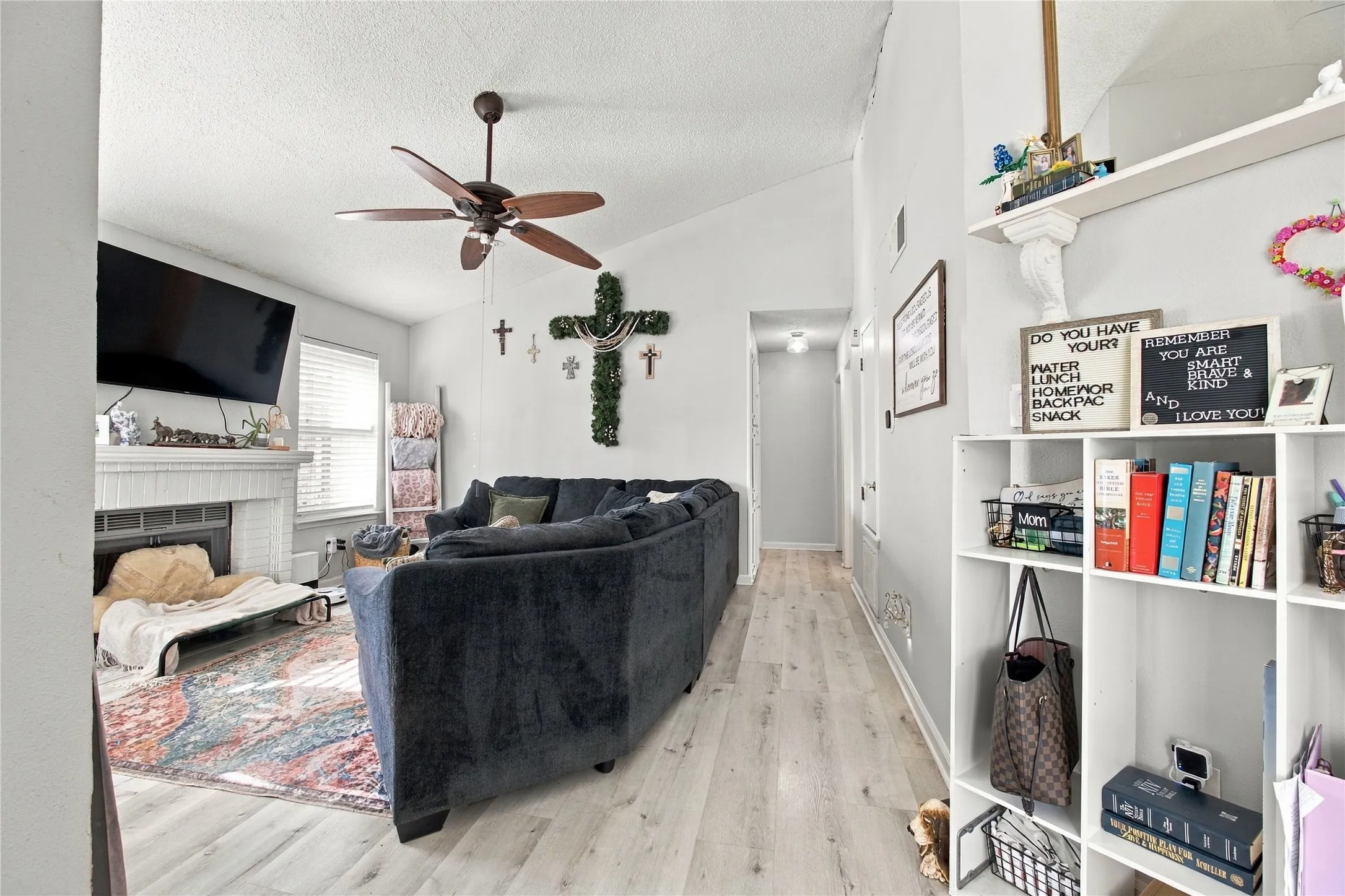 Vaulted ceilings with a ceiling fan, recessed lighting, and wood-finish flooring