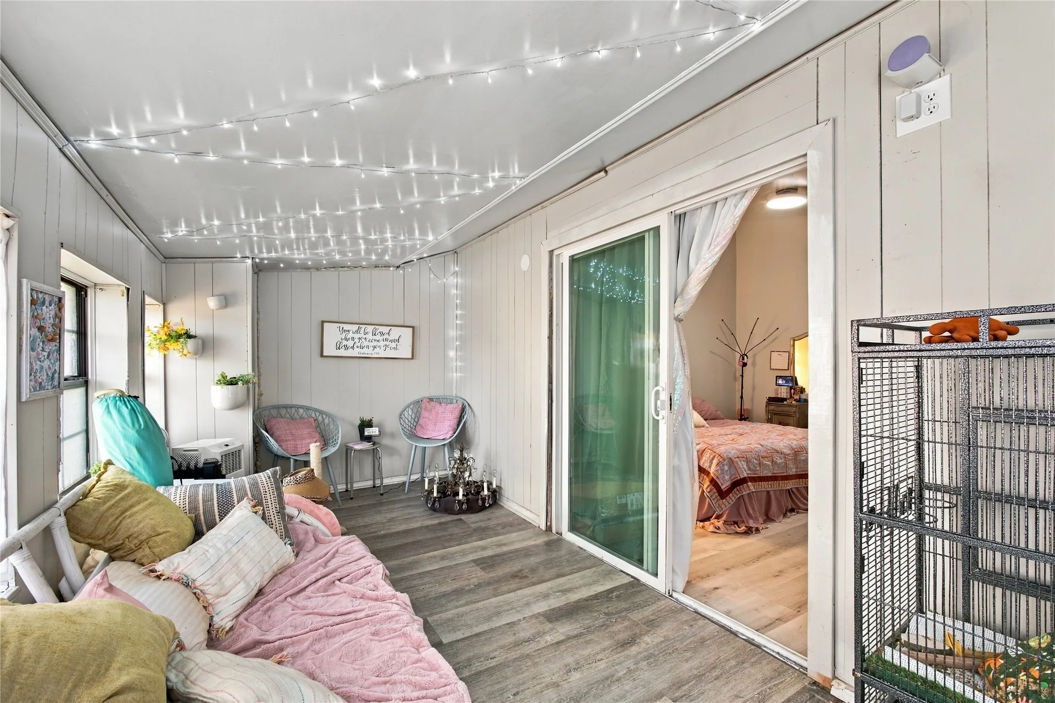 Enclosed porch featuring wood-finish flooring, vertical paneling, and a sliding glass door