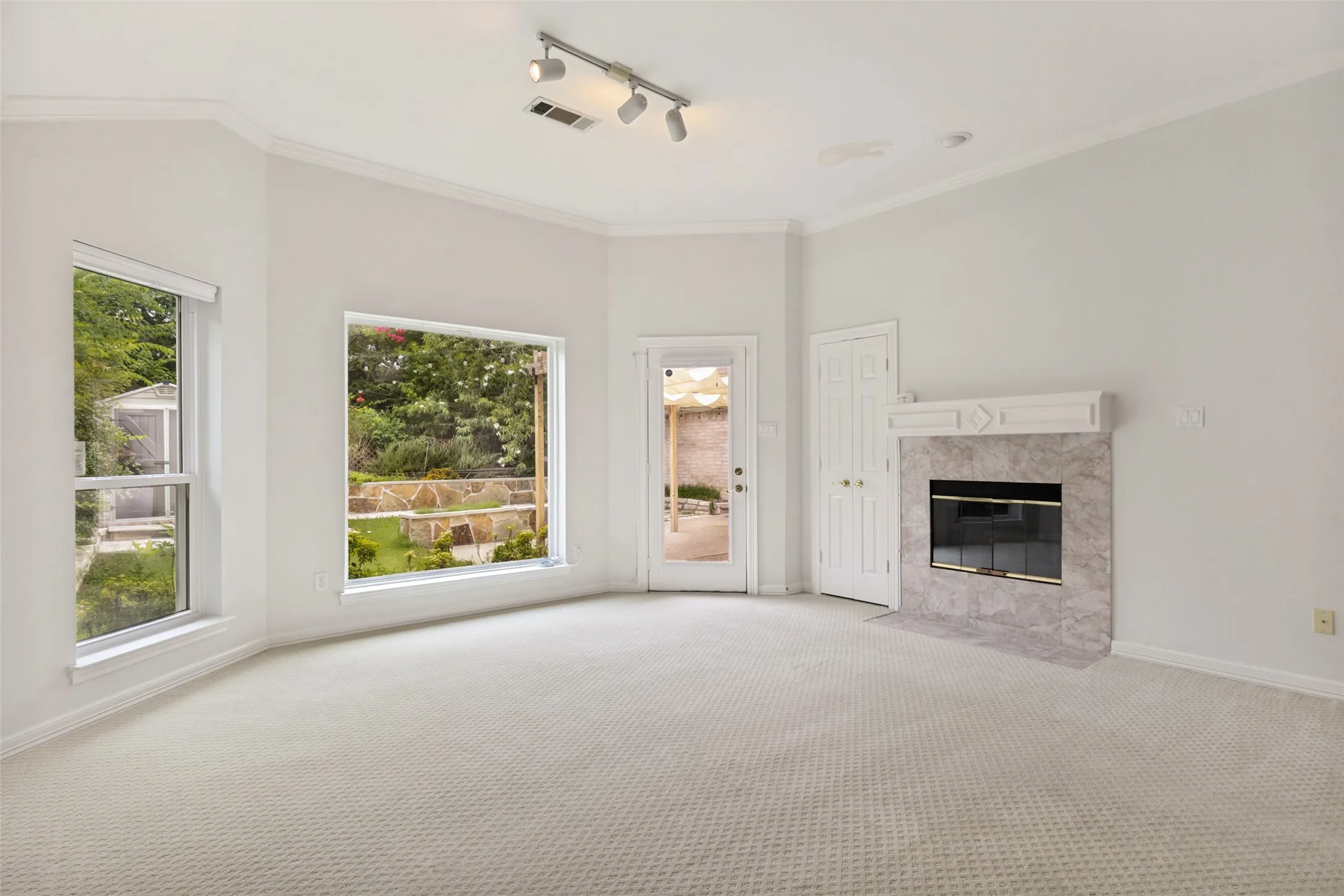 Vaulted ceiling room featuring a corner fireplace with a marble surround and white mantel