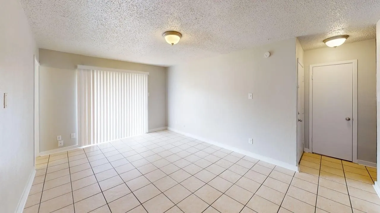 Tile flooring, sliding glass door with vertical blinds, overhead lighting, and neutral wall tones