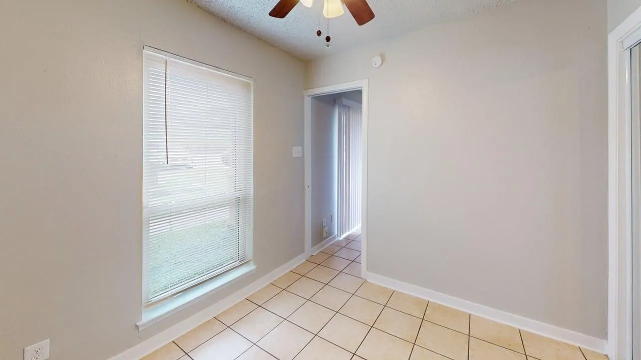 Window with blinds, ceiling fan, and tiled flooring