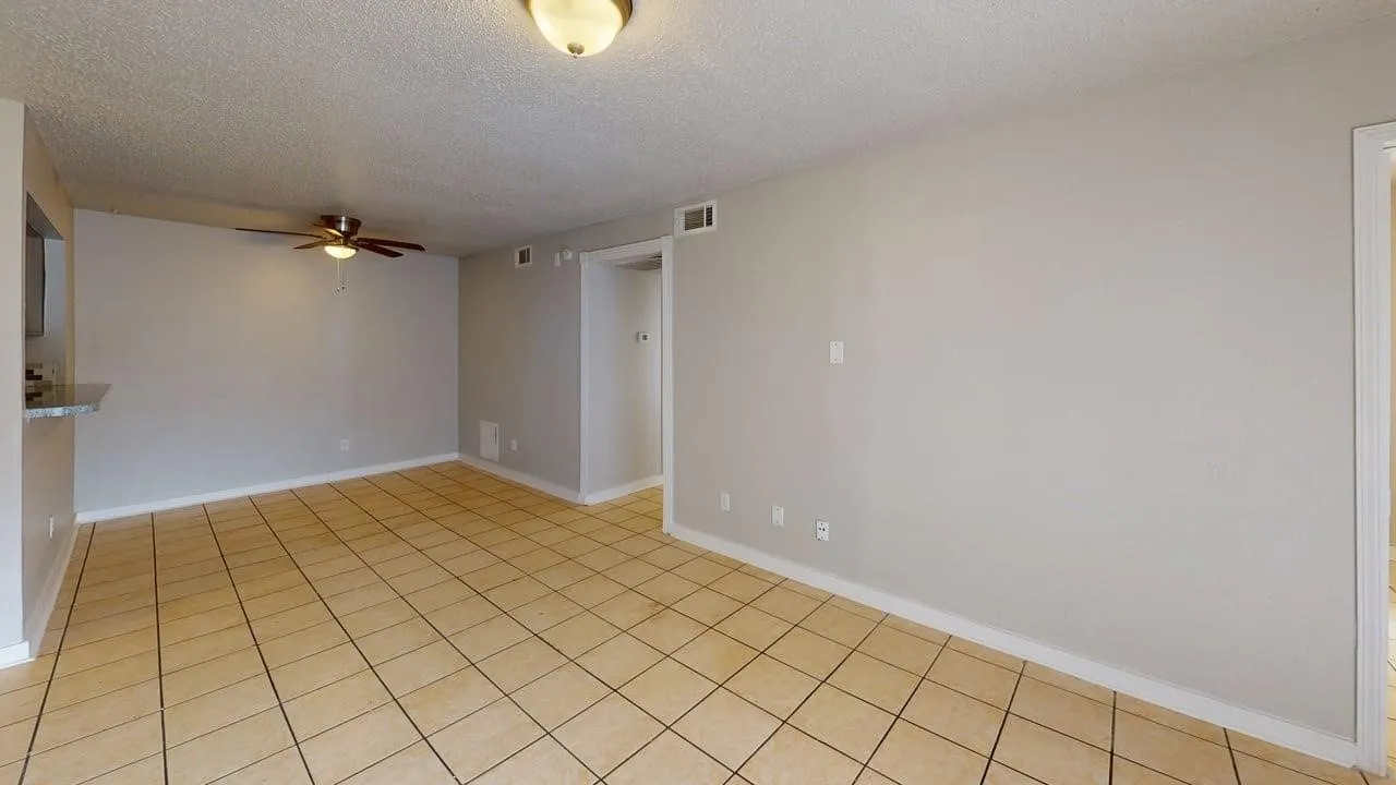 Tiled flooring, neutral wall paint, ceiling fan, and ceiling-mounted light fixture