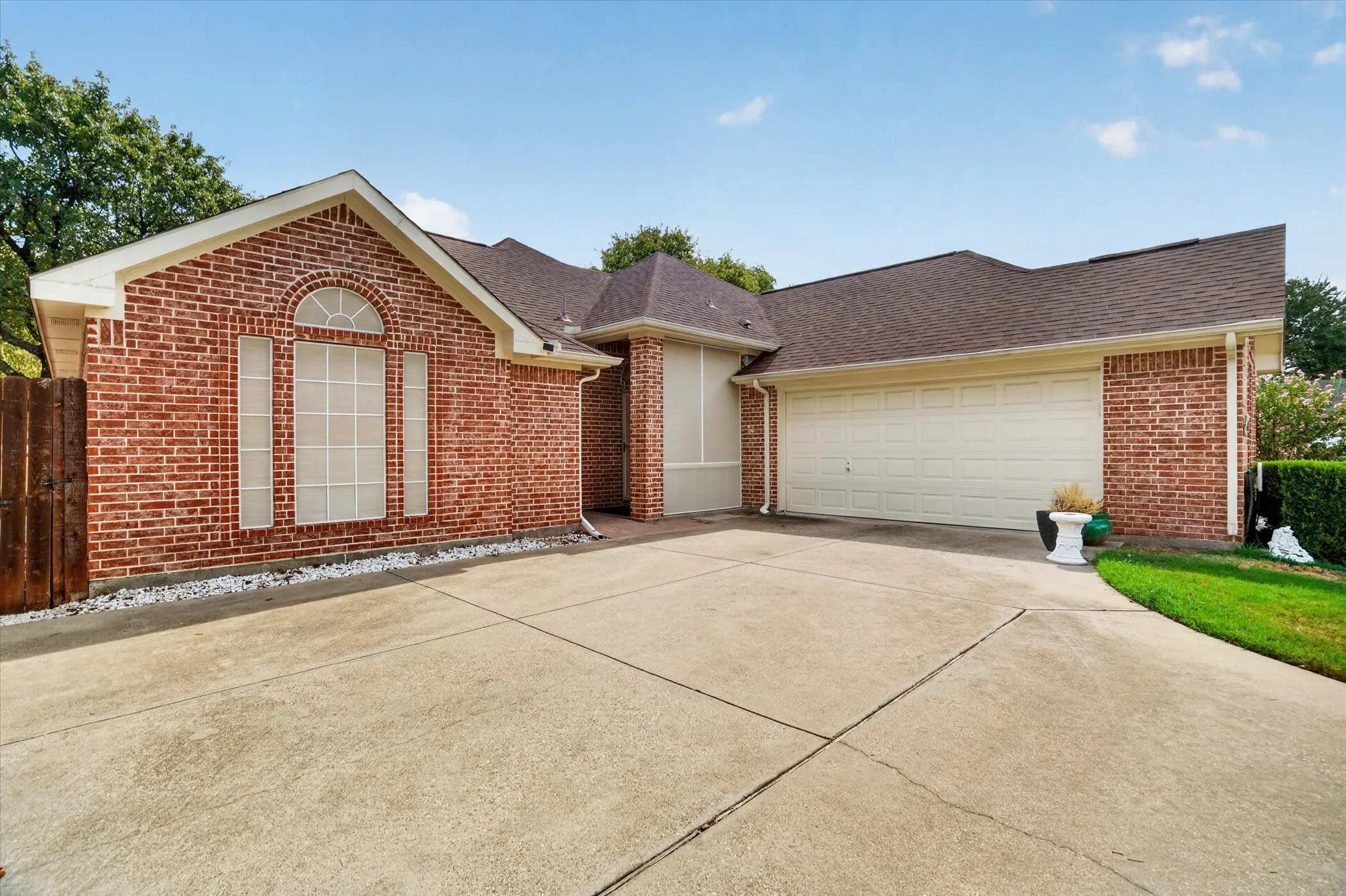 Brick exterior with an arched window and a two-car garage