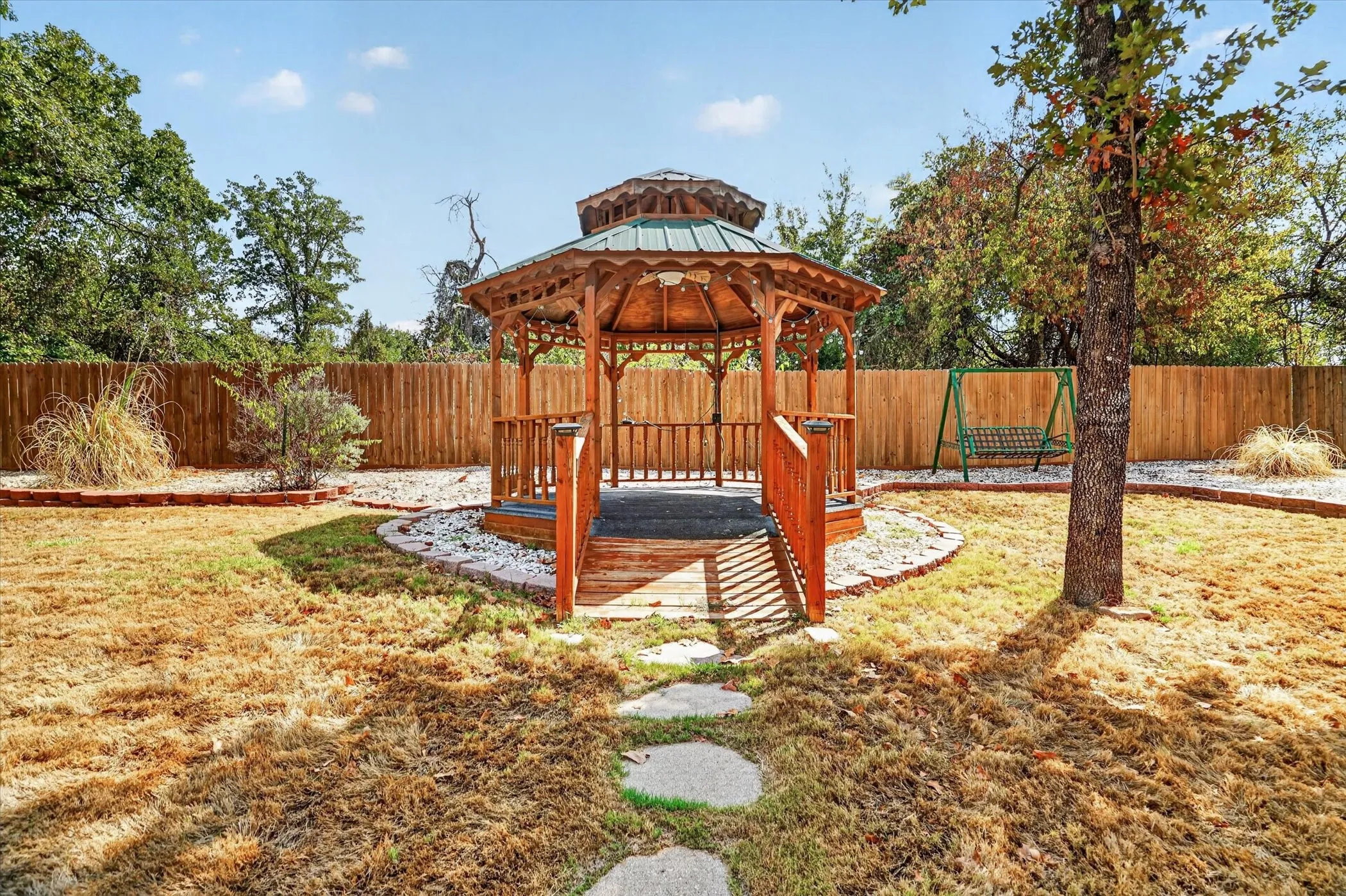 Wood-toned gazebo with a metal roof