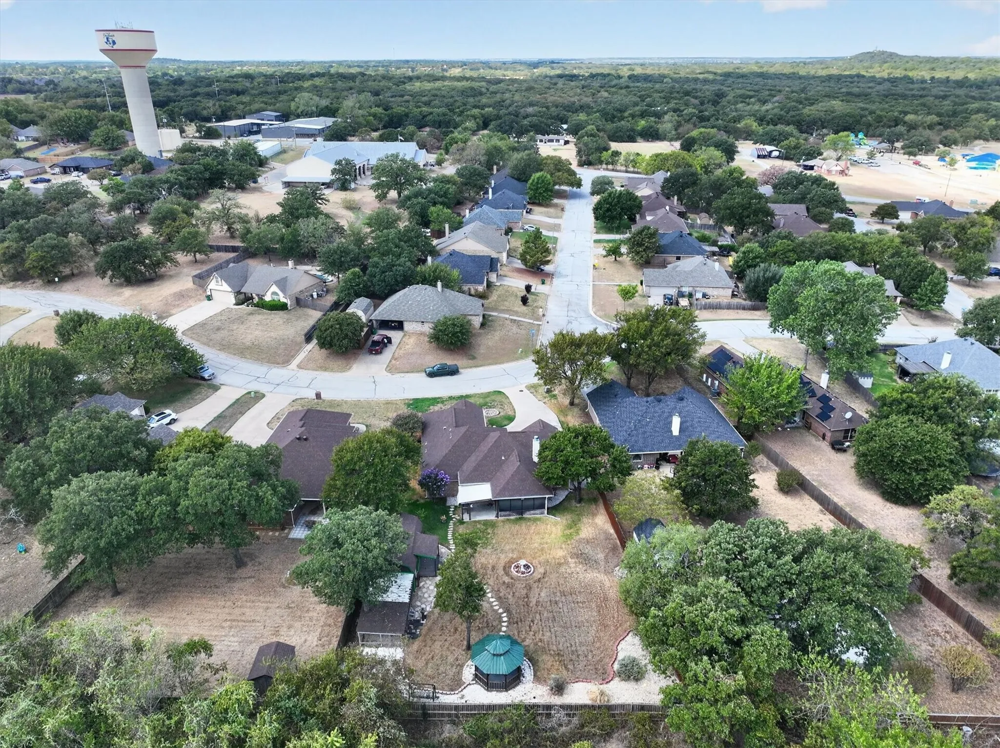 Residential neighborhood with mature trees, curved streets, and various home styles
