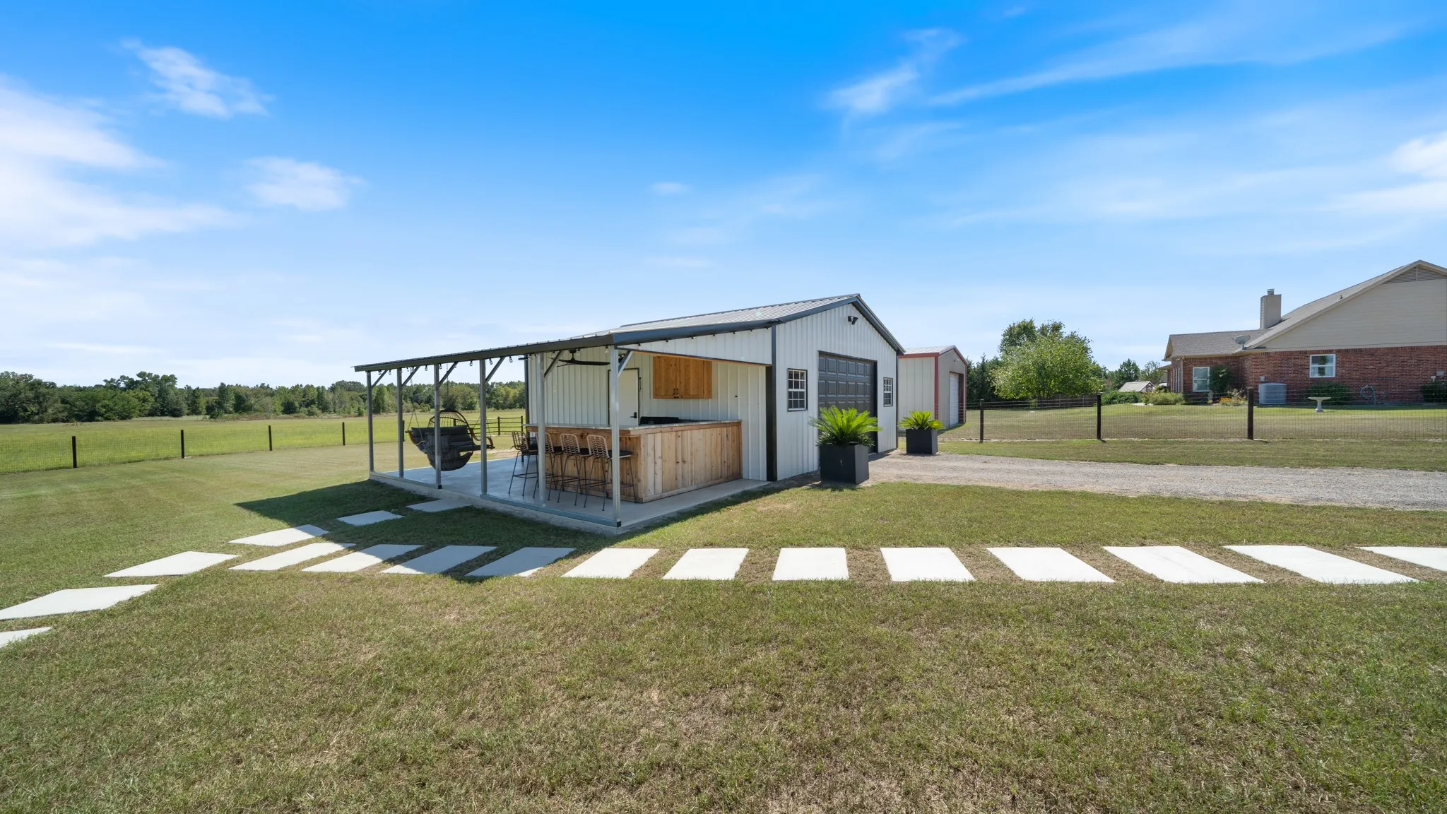 Modern agricultural structure featuring a metal-frame design with a gabled roof, wood-finish exterior siding, and a covered front entrance with ramp accessibility