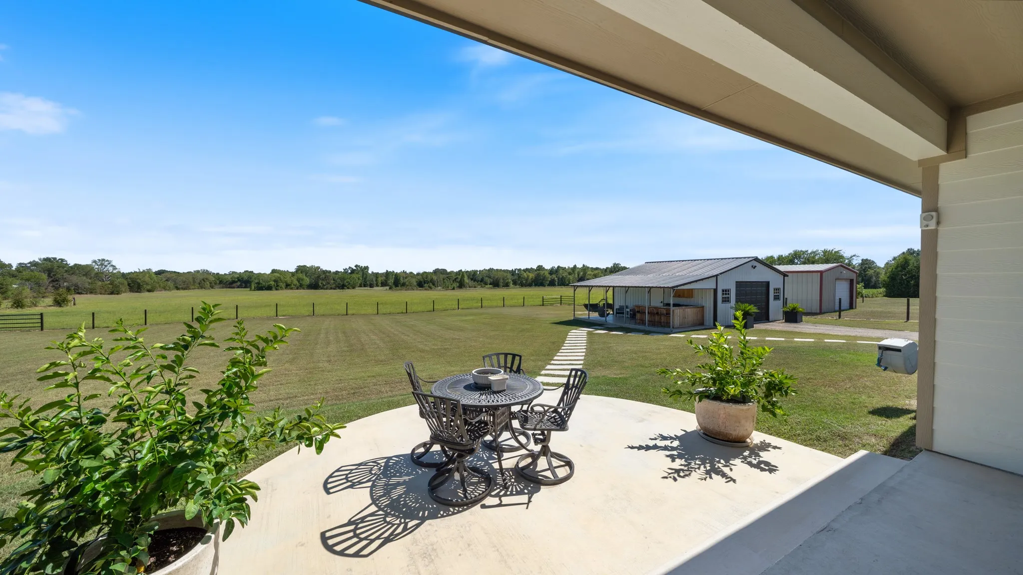 Expansive outdoor patio with a concrete surface, covered area, and open-air seating
