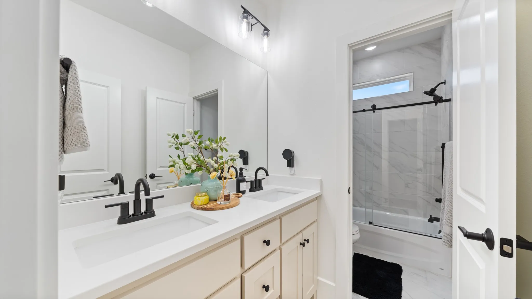 Dual vanity with integrated sinks, matte black fixtures, and a large mirror