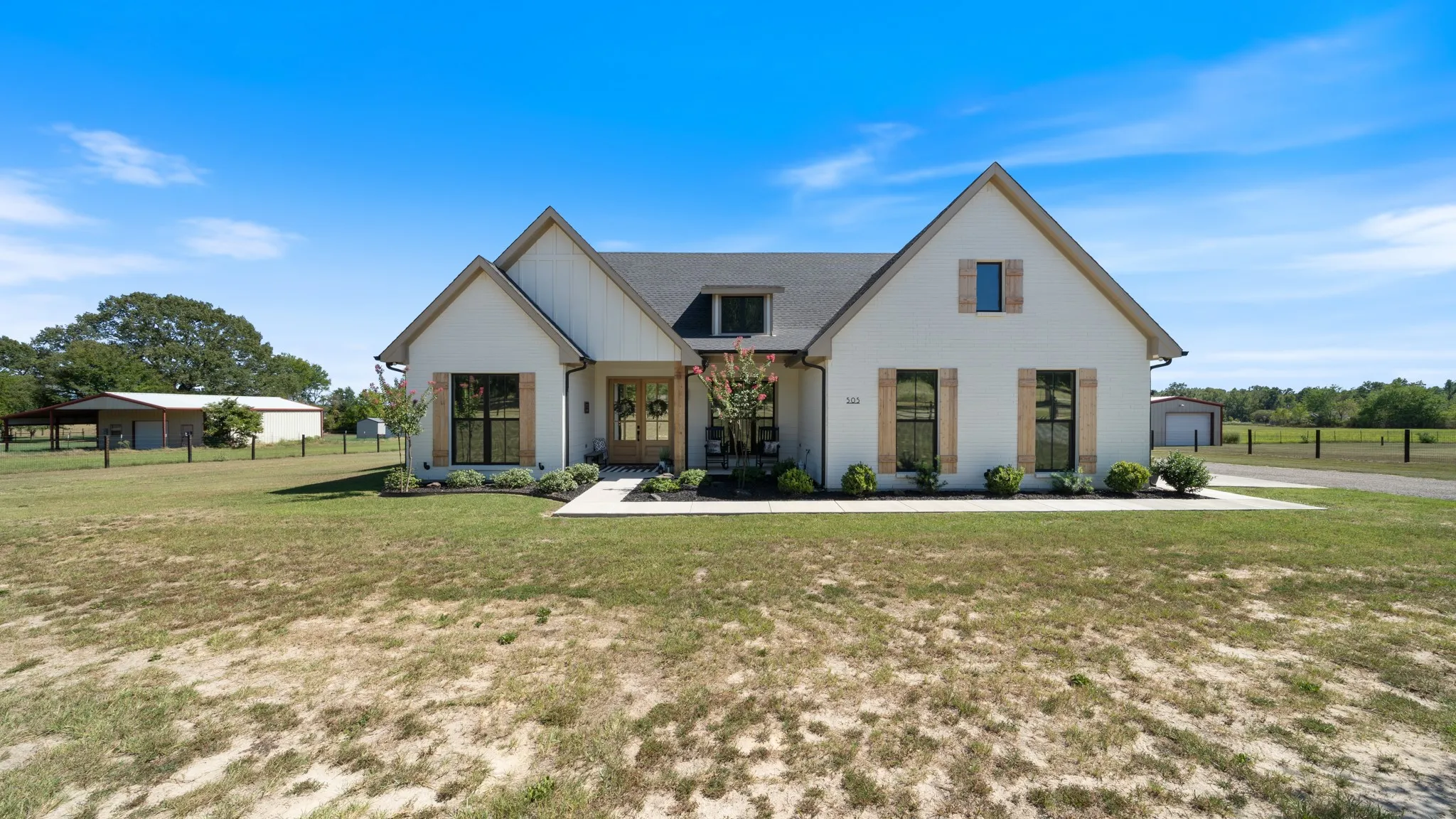 White exterior with contrasting dark window trim and natural wood-look shutters