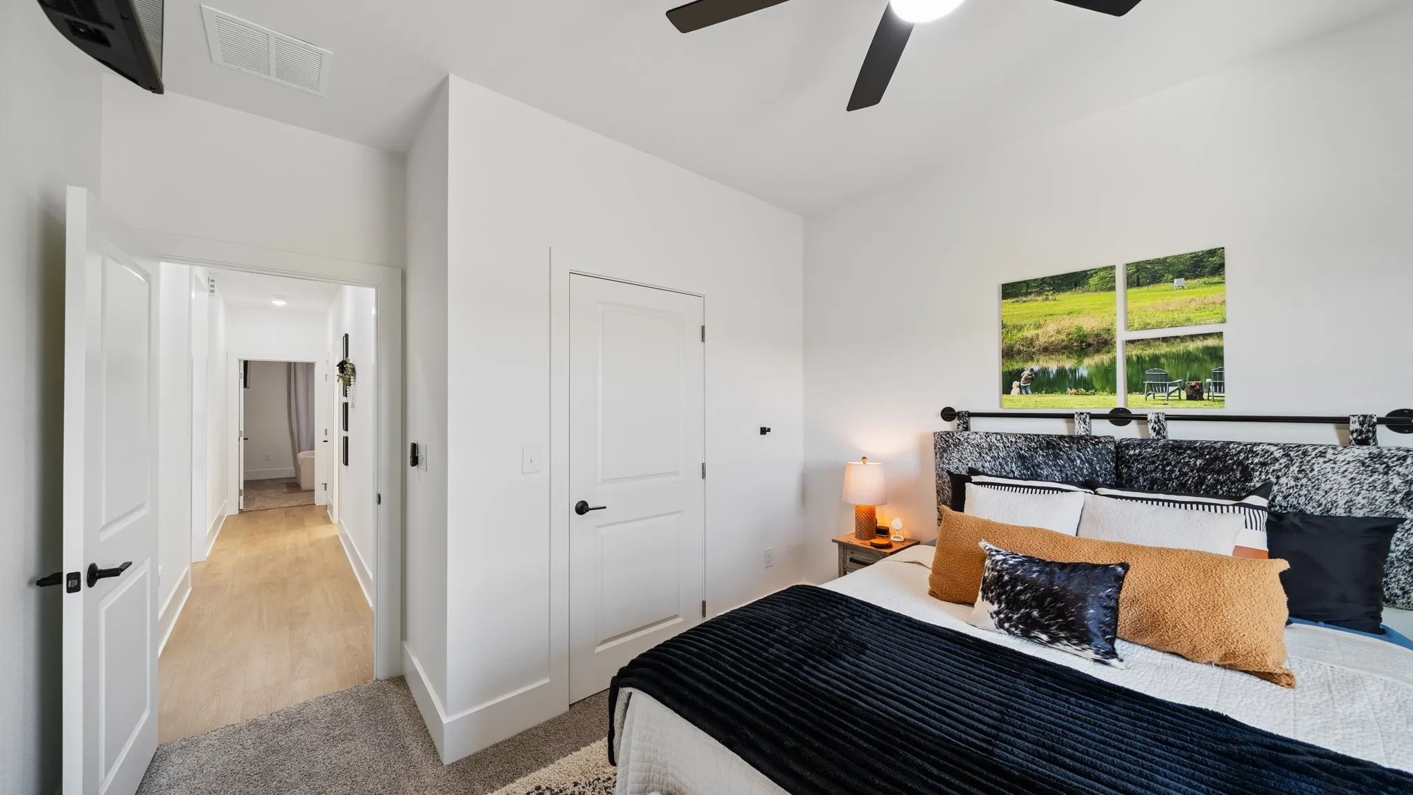Recessed lighting, wood-finish flooring, and white paneled doors with matte black hardware
