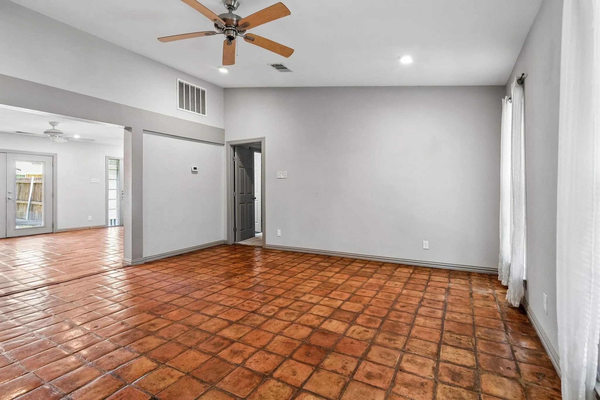 Living area with ceiling fan and windows for additional light