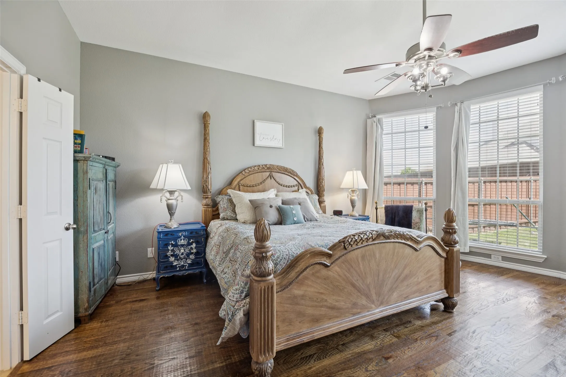 Wood-finish flooring, ample natural light from multiple windows, ceiling fan with integrated lighting, and neutral wall​​‌​​​​‌​​‌‌​‌‌​​​‌‌​‌​‌​‌​​​‌​​ tones