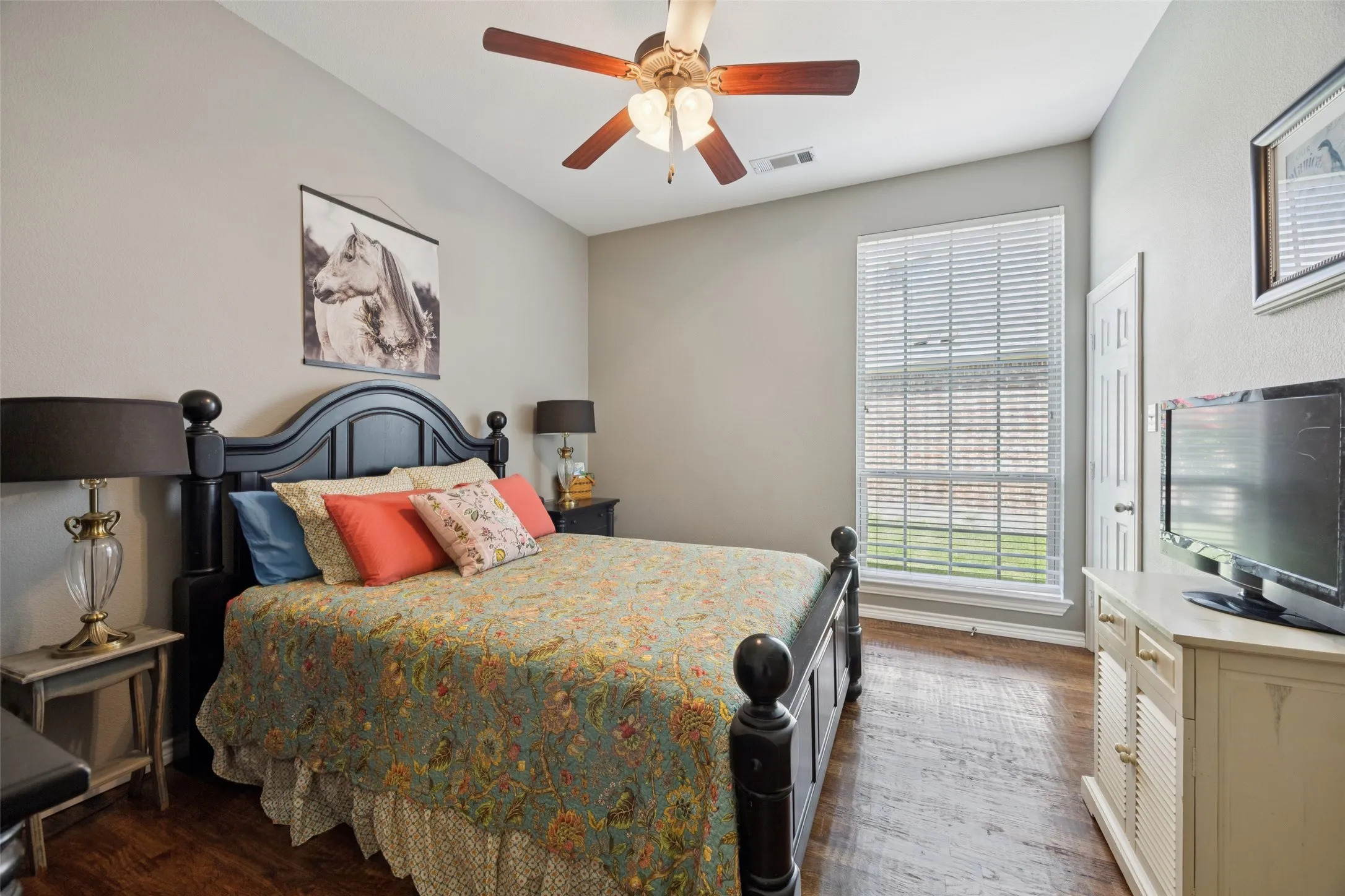 Vaulted ceiling, wood-finish flooring, ceiling fan, and window with blinds