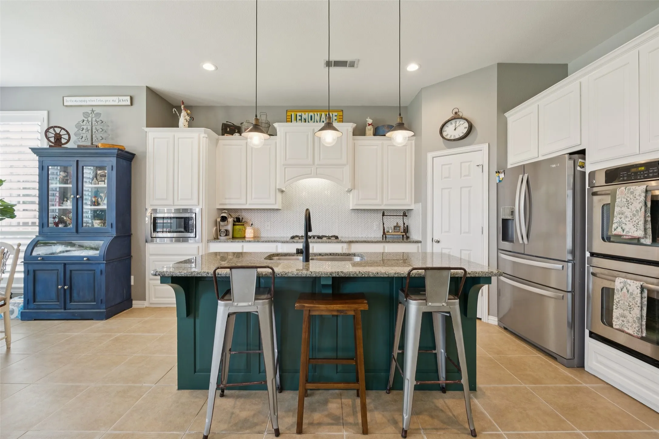 Kitchen featuring a central island with countertop seating, stainless steel appliances, white cabinetry, and recessed lighting