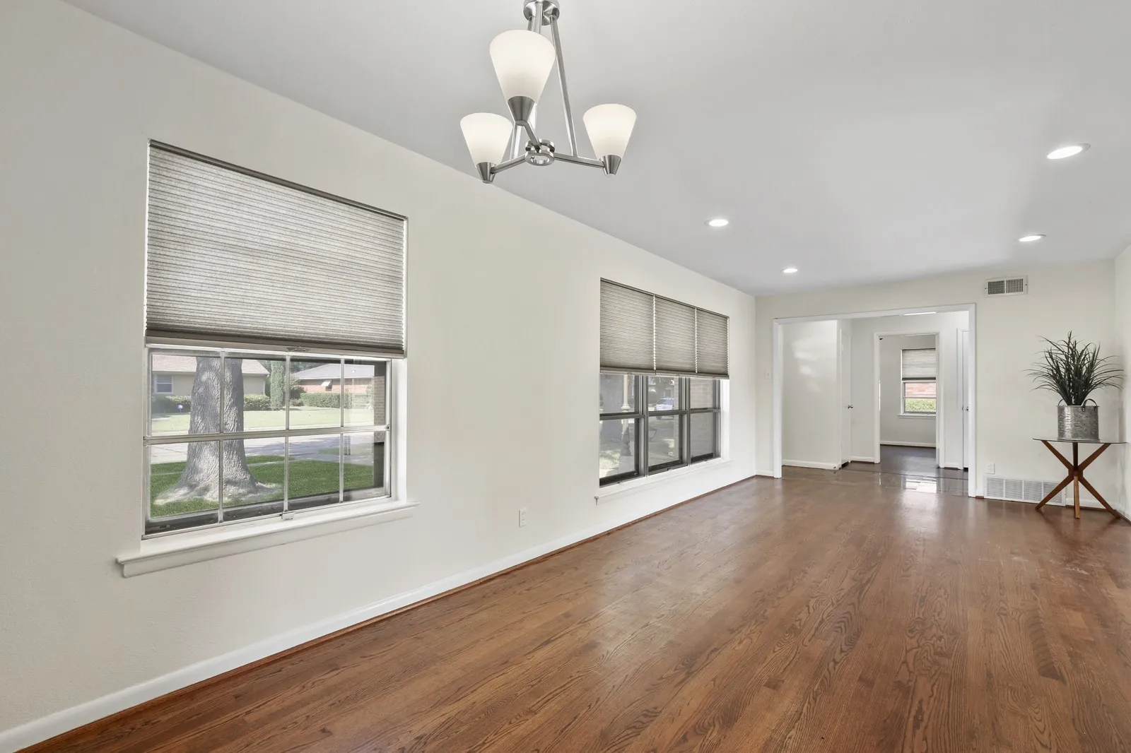 Hardwood flooring, recessed lighting, and a modern chandelier