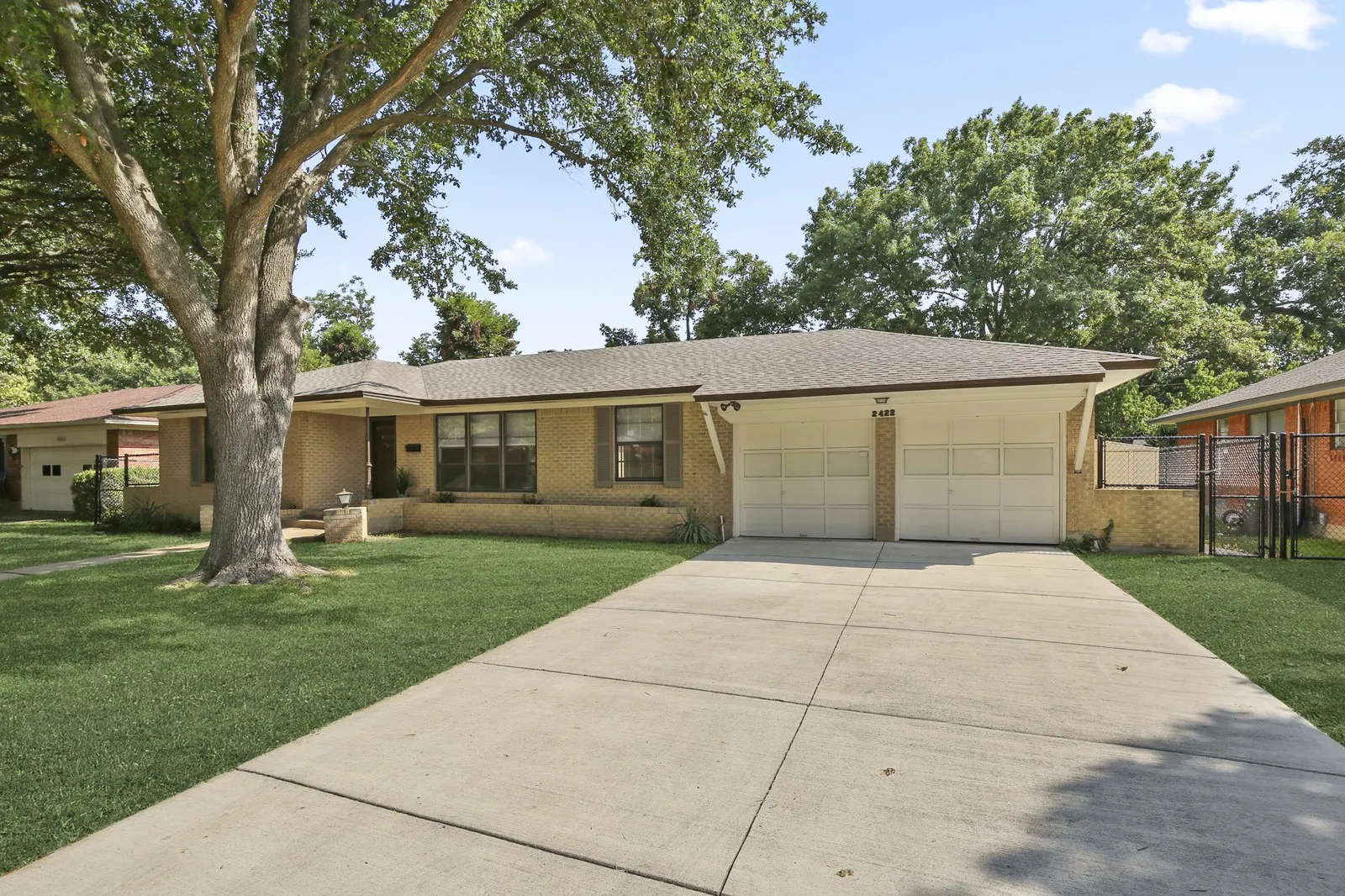 Brick exterior with a gabled roof, a two-car garage, and a concrete driveway