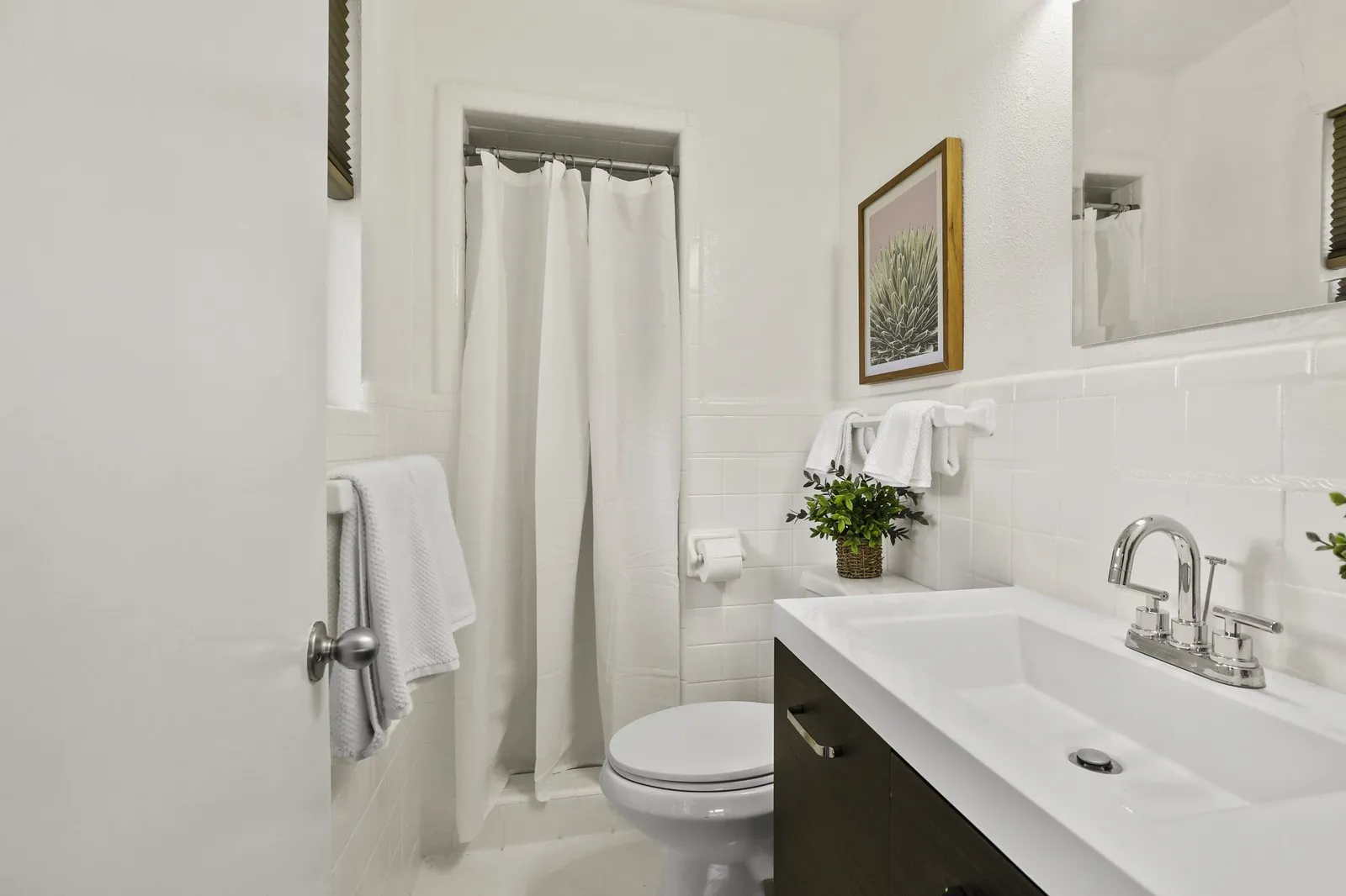 Integrated vanity with a single basin, chrome faucet, and dark wood-finish cabinetry