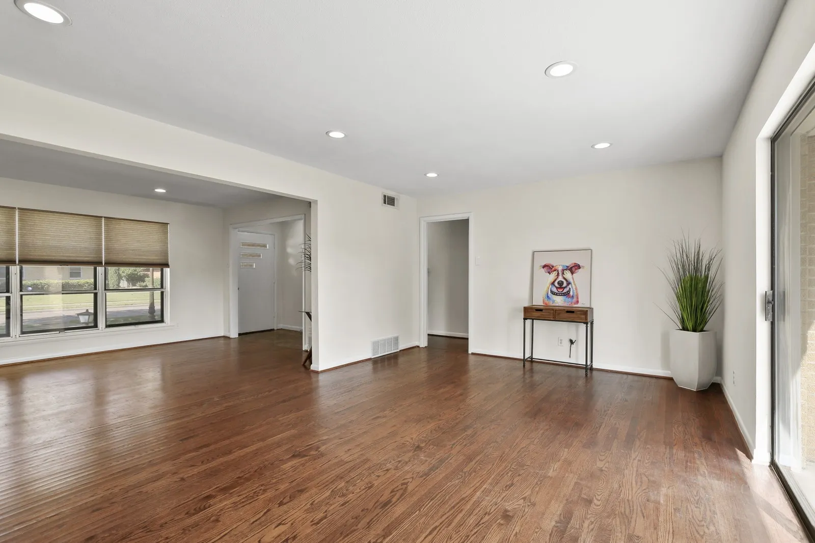 Hardwood flooring throughout, recessed lighting, and multiple windows with blinds