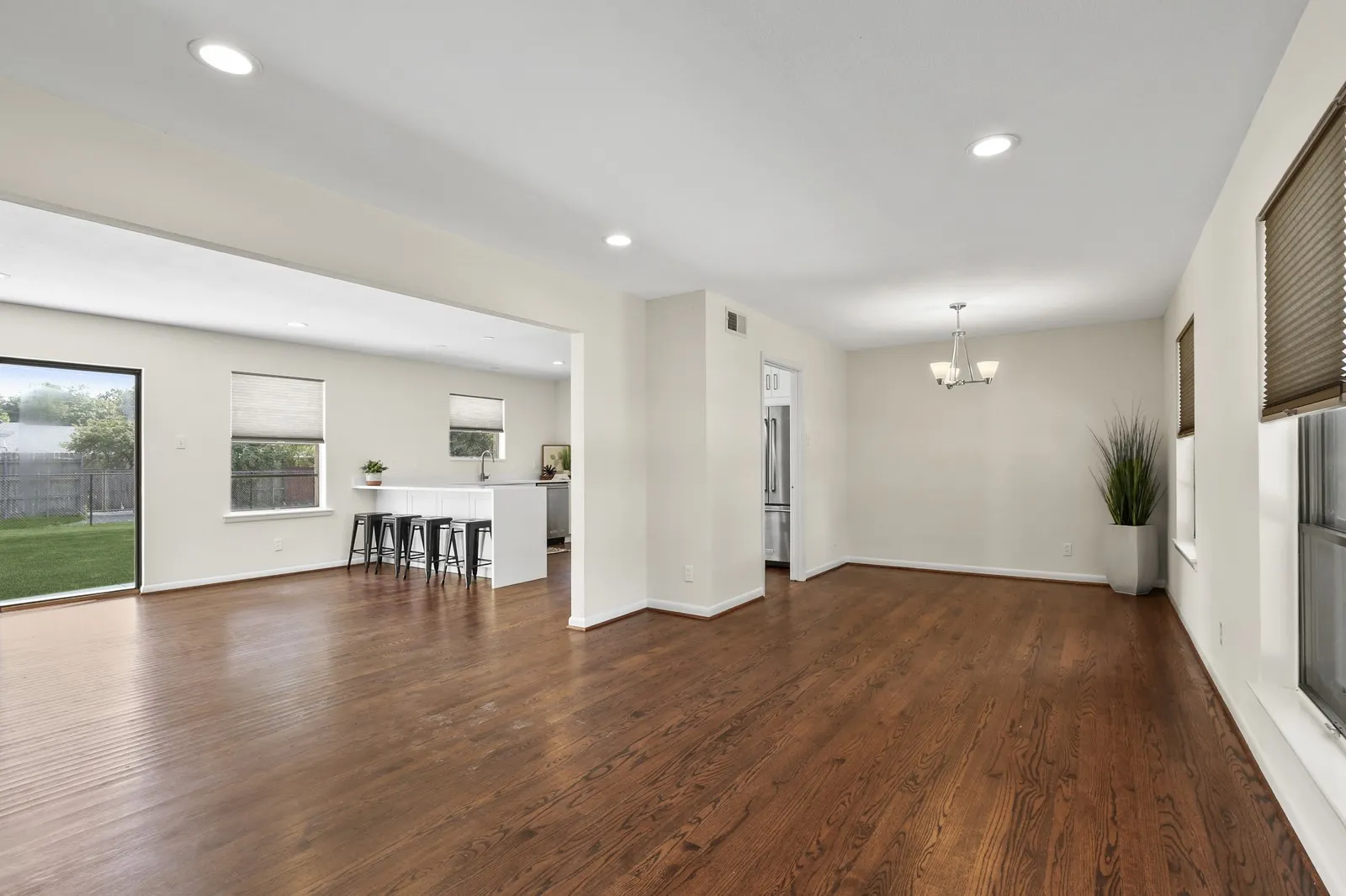 Wood-finish flooring throughout, recessed lighting, and a modern kitchen island with seating