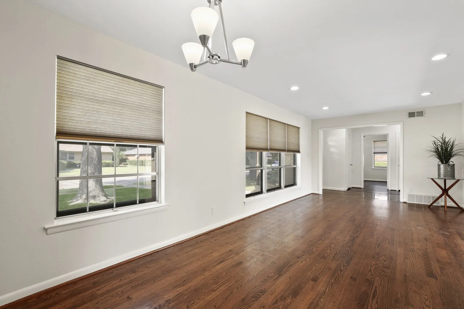 Wood-finish flooring, recessed lighting, and a contemporary chandelier