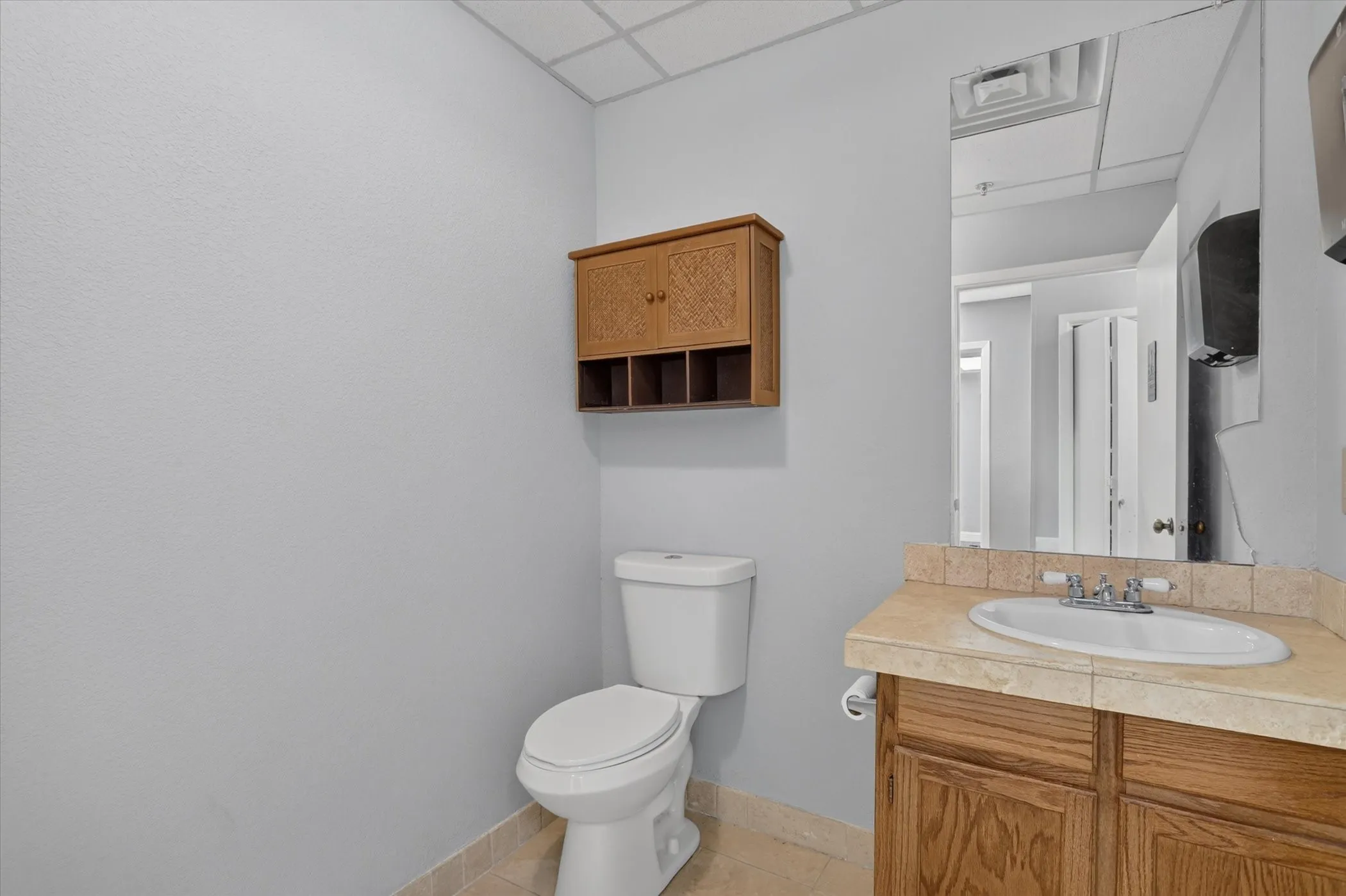Vanity with an integrated sink, wood-finish cabinetry, and a stone-finish countertop