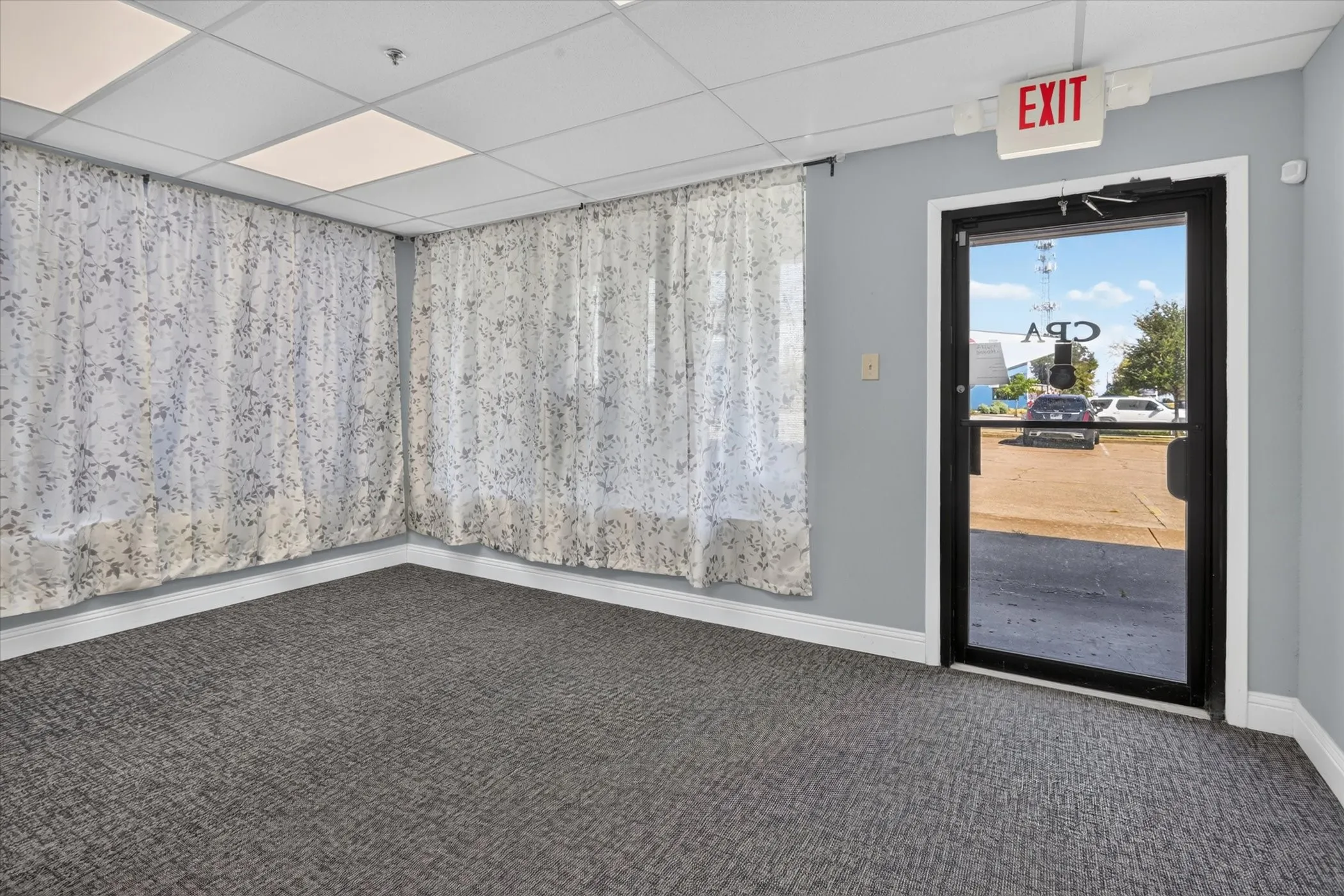 Commercial-grade carpet flooring and drop ceiling with integrated lighting
