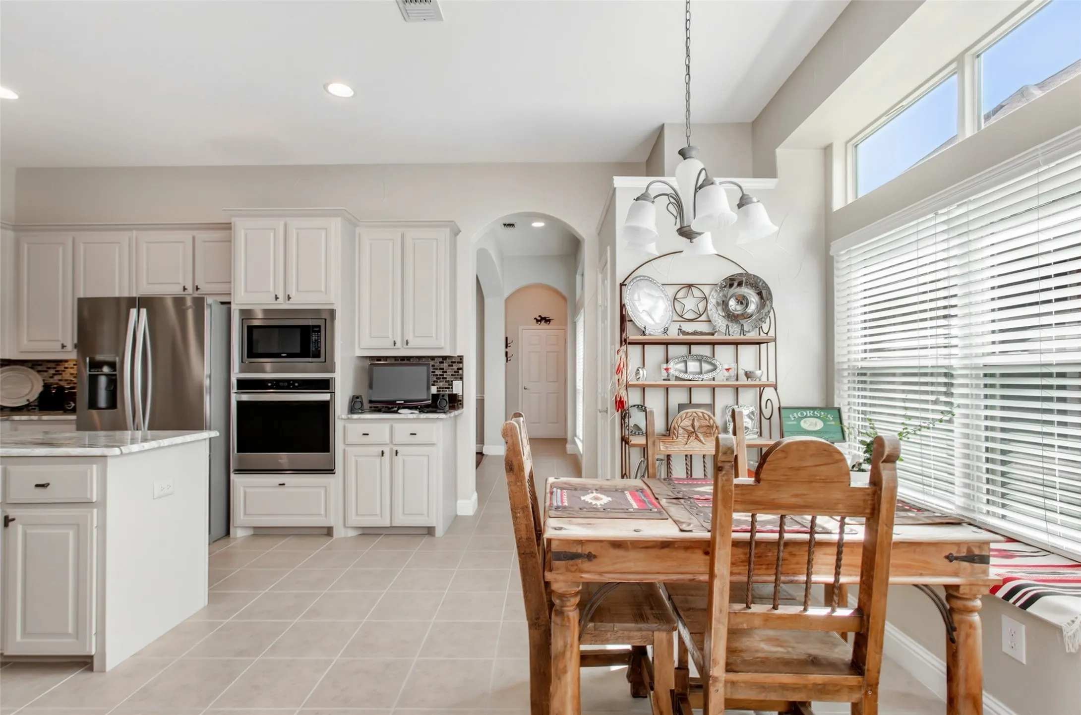 Kitchen with white cabinetry, stainless steel appliances, and a built-in oven/microwave combination