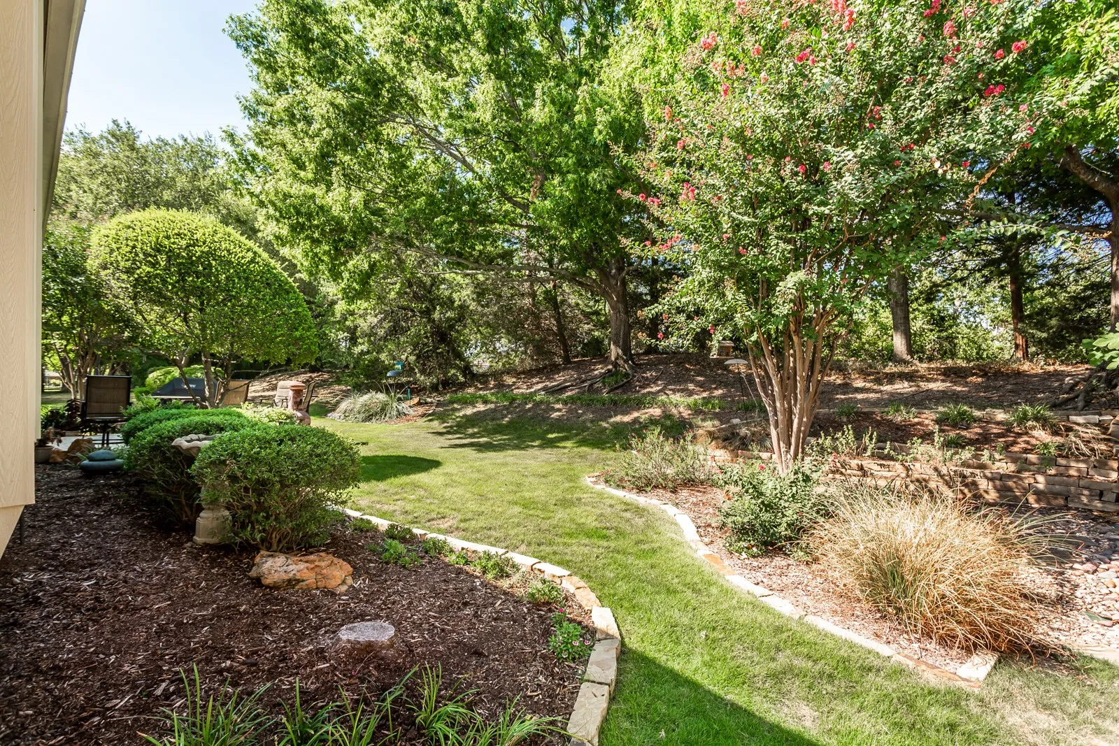 Expansive lawn area with natural landscaping and mature trees