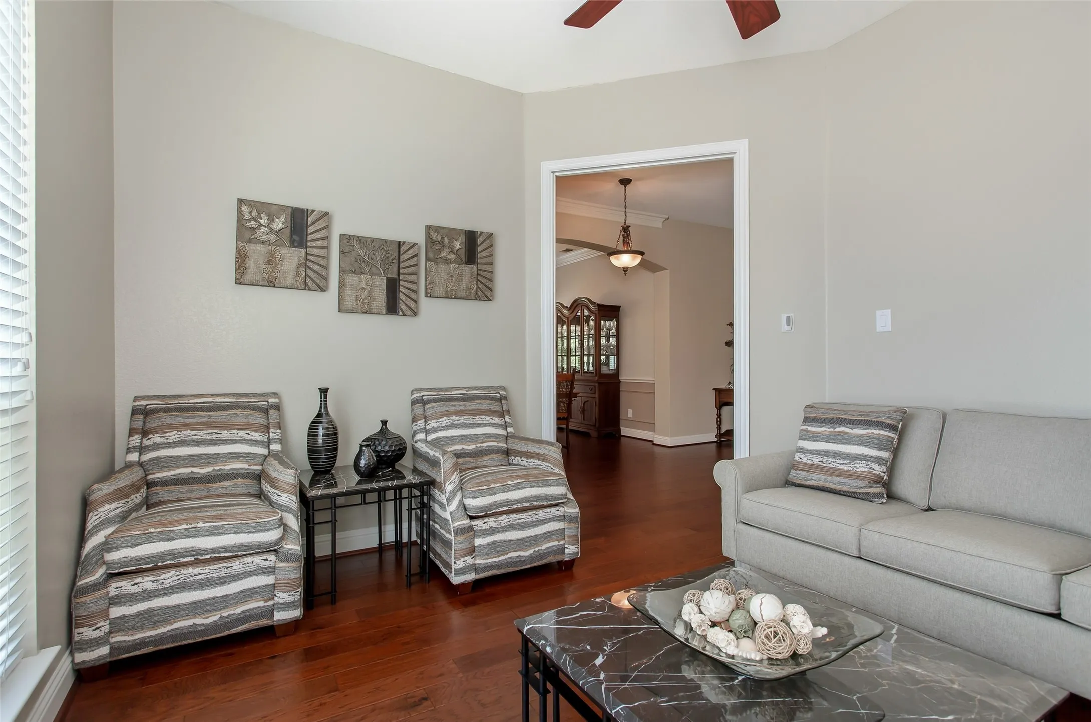 Wood-finish flooring, neutral wall tones, and an open doorway to an adjacent room
