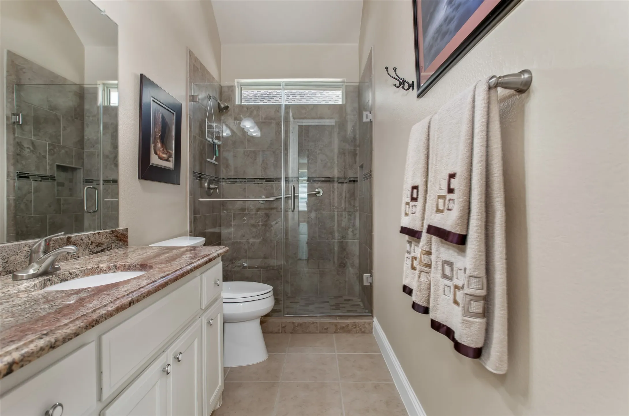 White vanity with a stone countertop and integrated sink