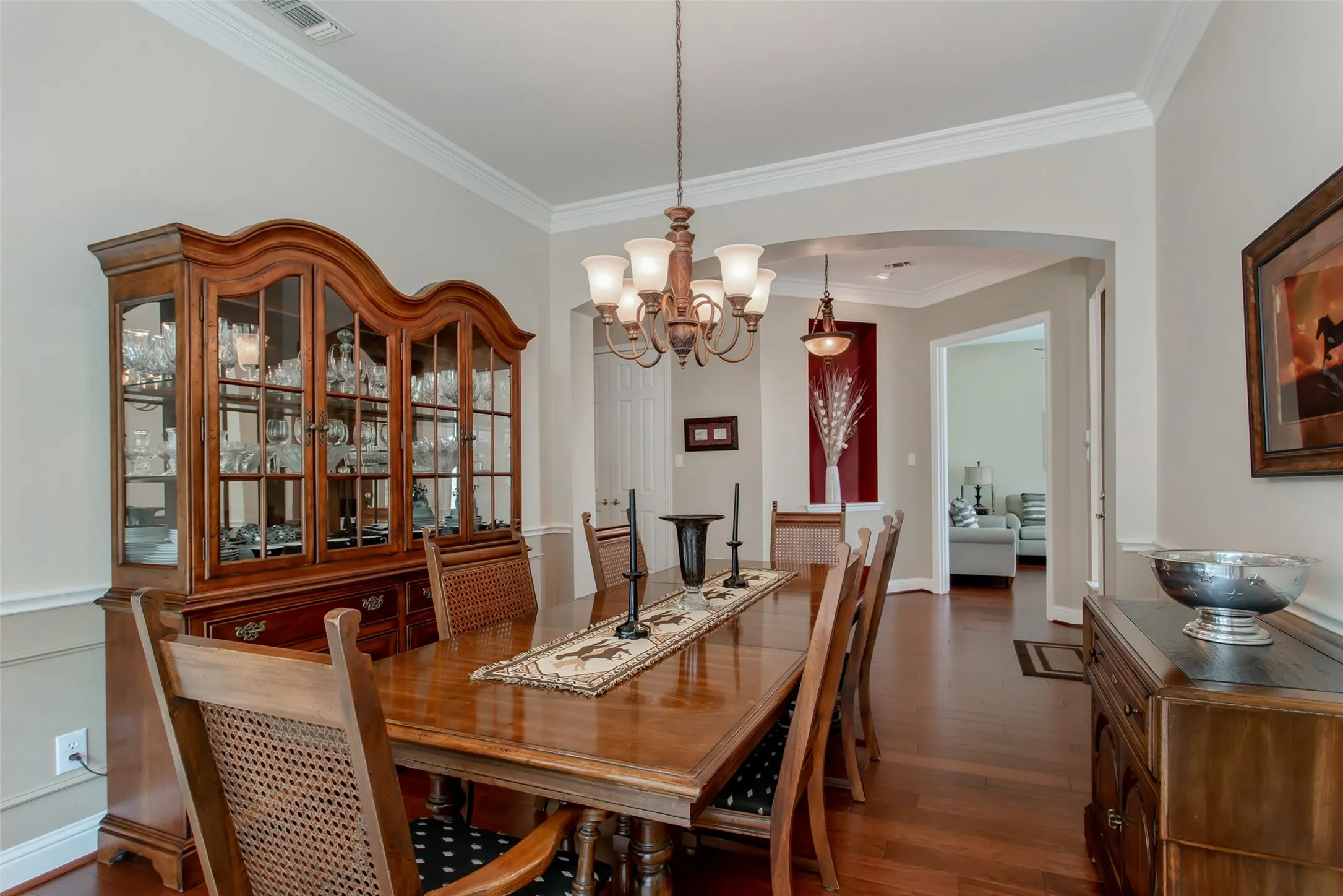 Hardwood flooring, crown molding, chair rail molding, arched entryway, and recessed lighting